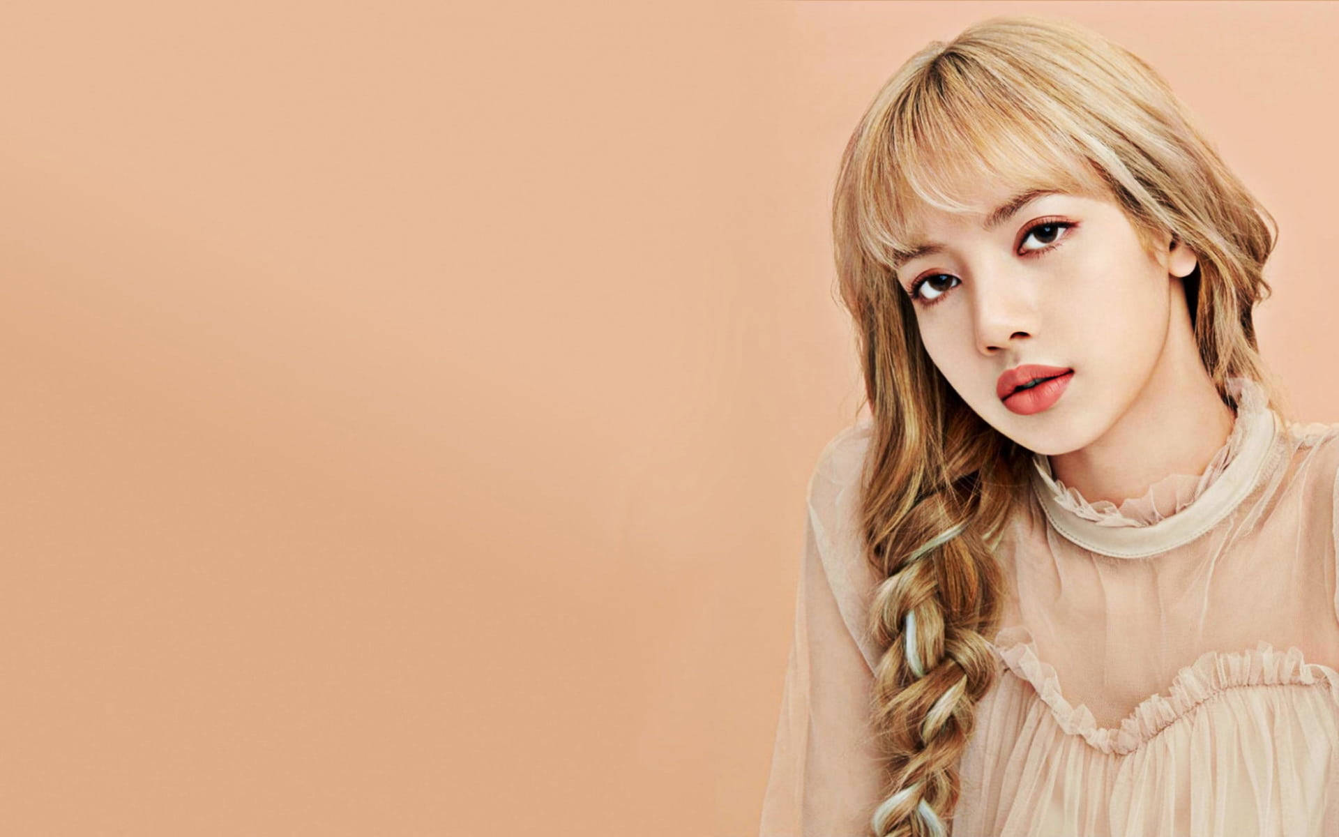 lisa 桌布 壁紙 — 一位金髮辮子、妝容柔和的年輕女性，在純色蜜桃色背景下直視鏡頭。