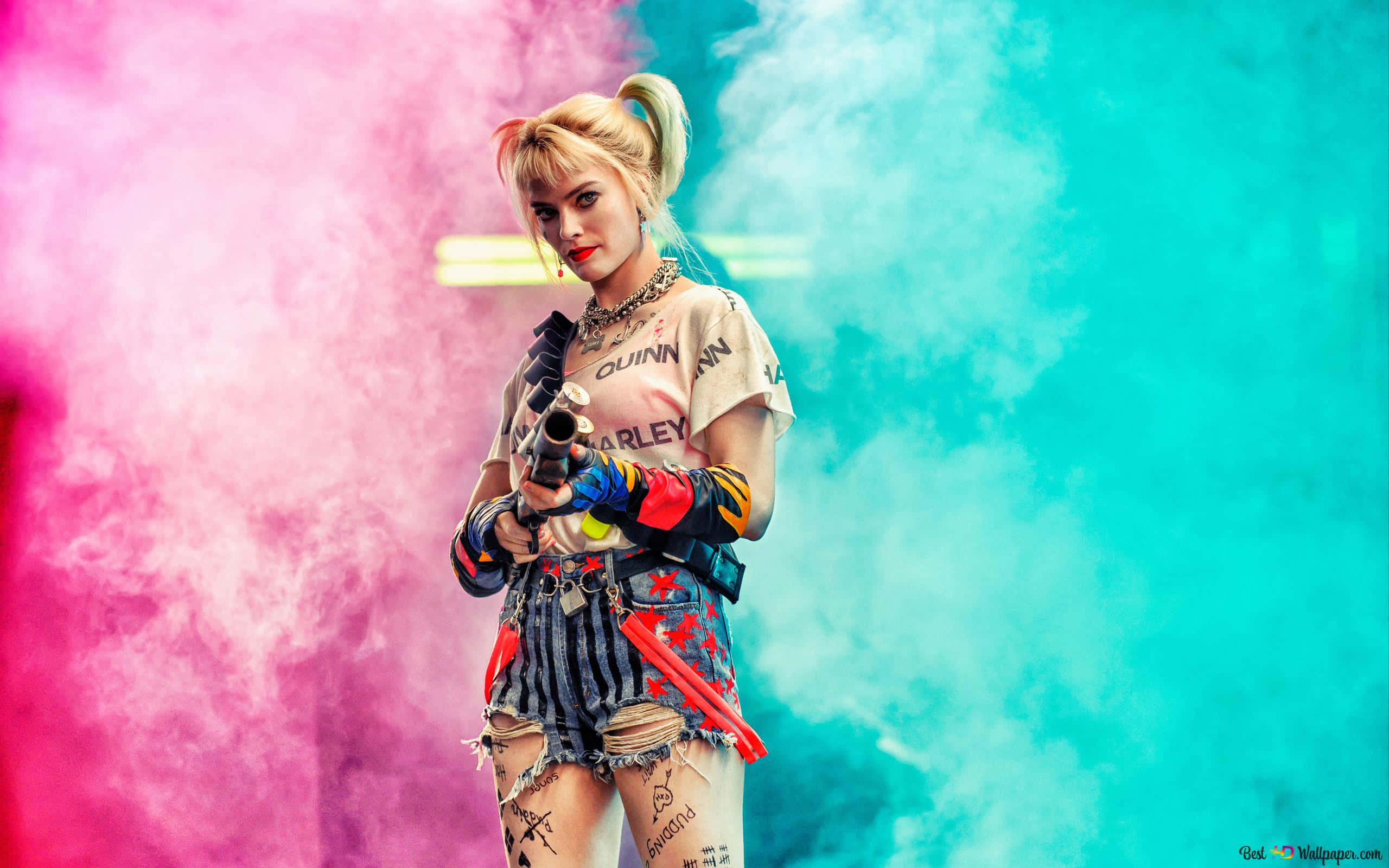 Margot Robbie Harley Quinn 桌布 壁紙 — 一位金髮辮子、有刺青的女性，在充滿活力的粉紅和青色煙霧背景下持槍。
