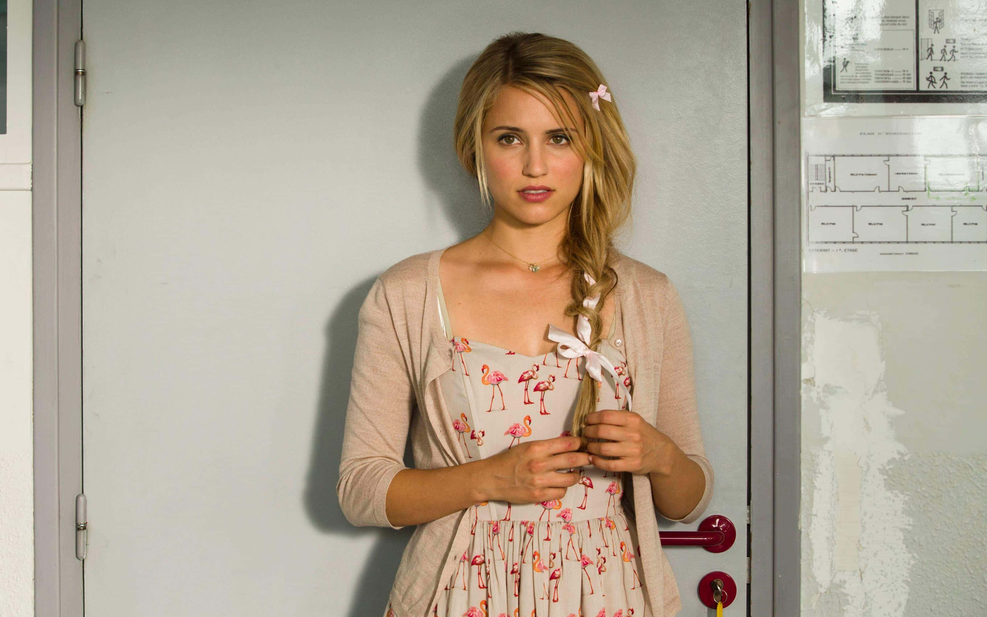 dianna agron 桌布 壁紙 — 一位金髮辮子年輕女子站在門口，身穿火鶴印花連衣裙和米色開襟衫。