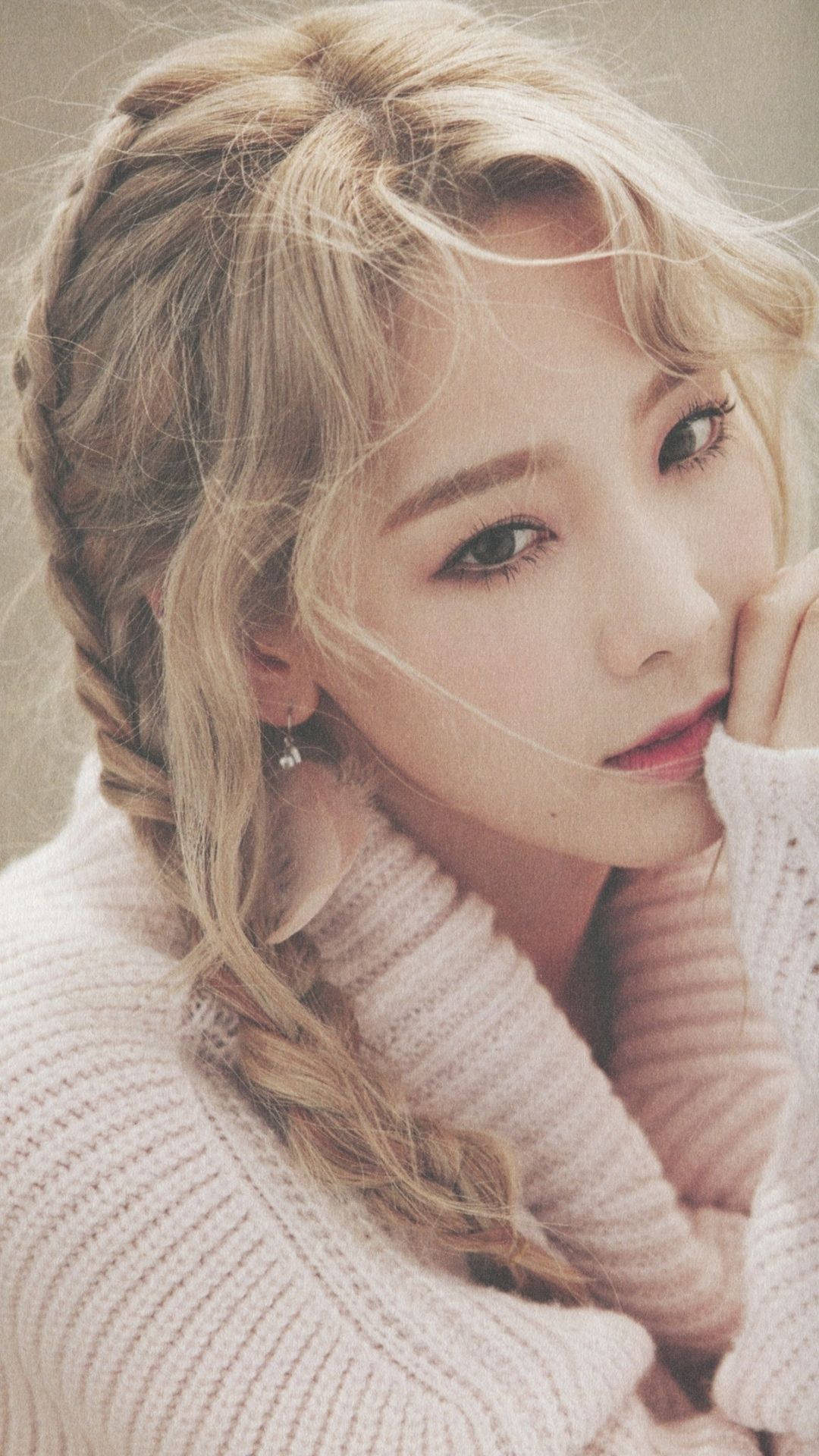 Taeyeon 桌布 壁紙 — 一位金髮辮子年輕女性，穿著舒適的針織毛衣，托腮溫柔凝視。