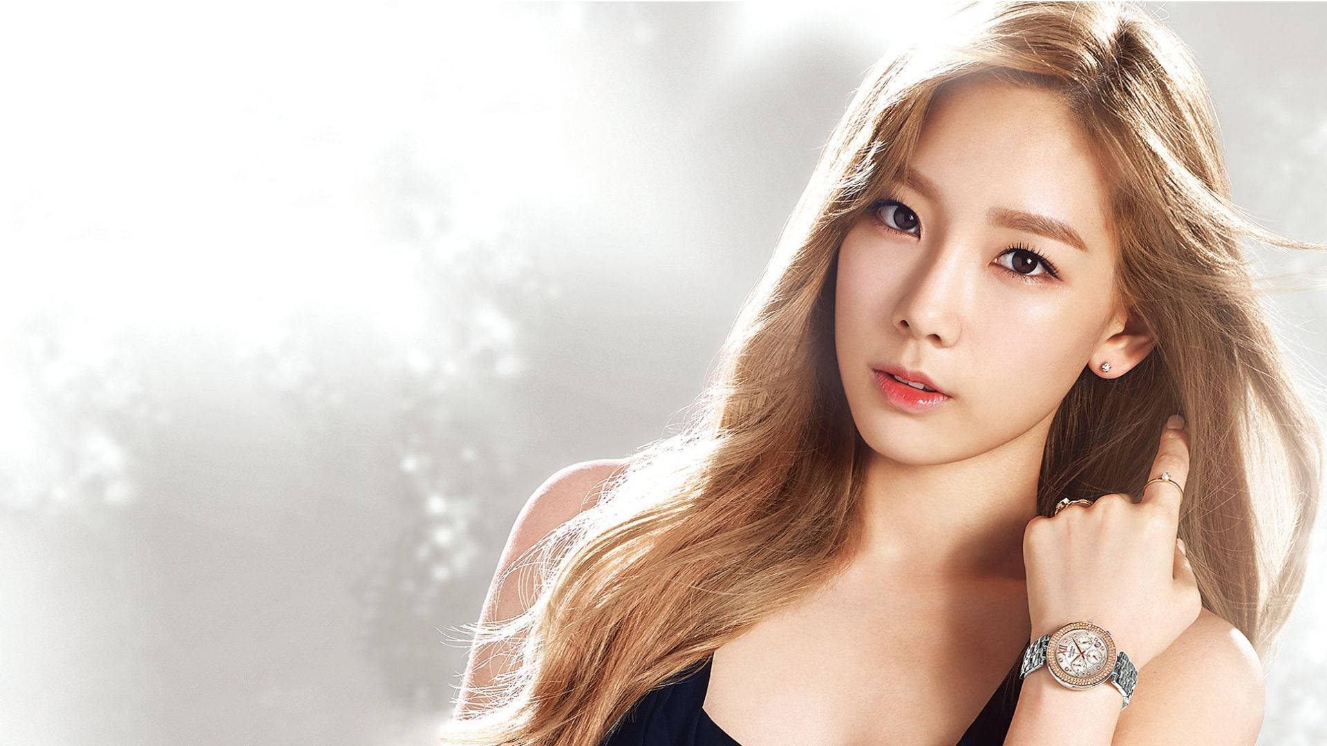 Taeyeon 桌布 壁紙 — 一位金髮長髮的迷人女性，在明亮朦朧的背景中佩戴手錶和戒指，溫柔地凝視著。