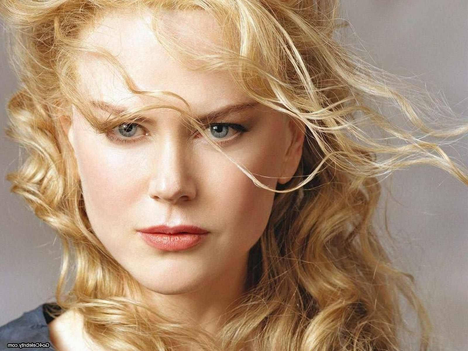 Nicole 桌布 壁紙 — 一位金髮飄逸、藍眼深邃的女性特寫肖像，直視觀眾。