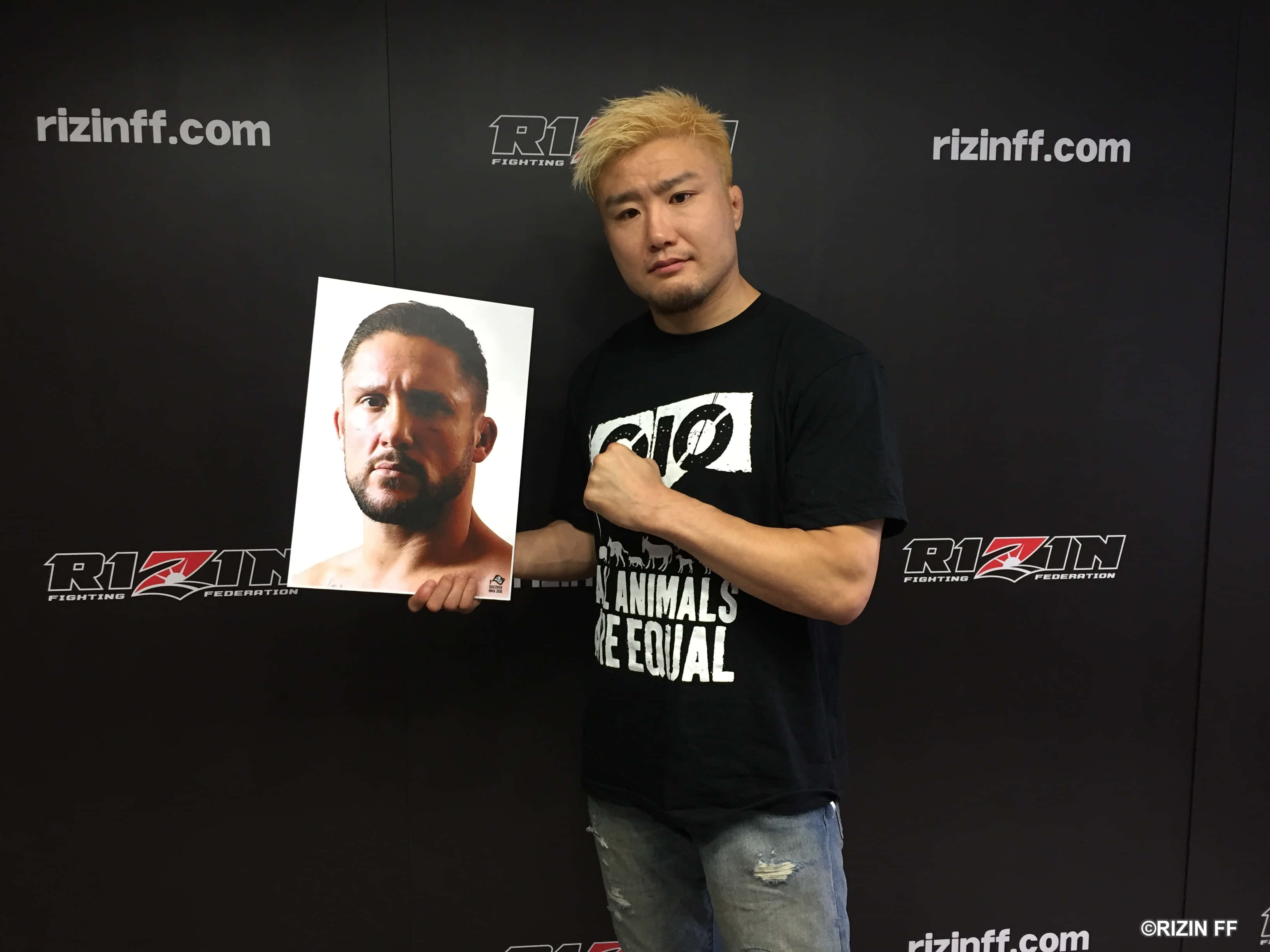 UFC 桌布 壁紙 — 一位金髮鬥士在黑色Rizin FF品牌背景前手持另一位鬥士的肖像。