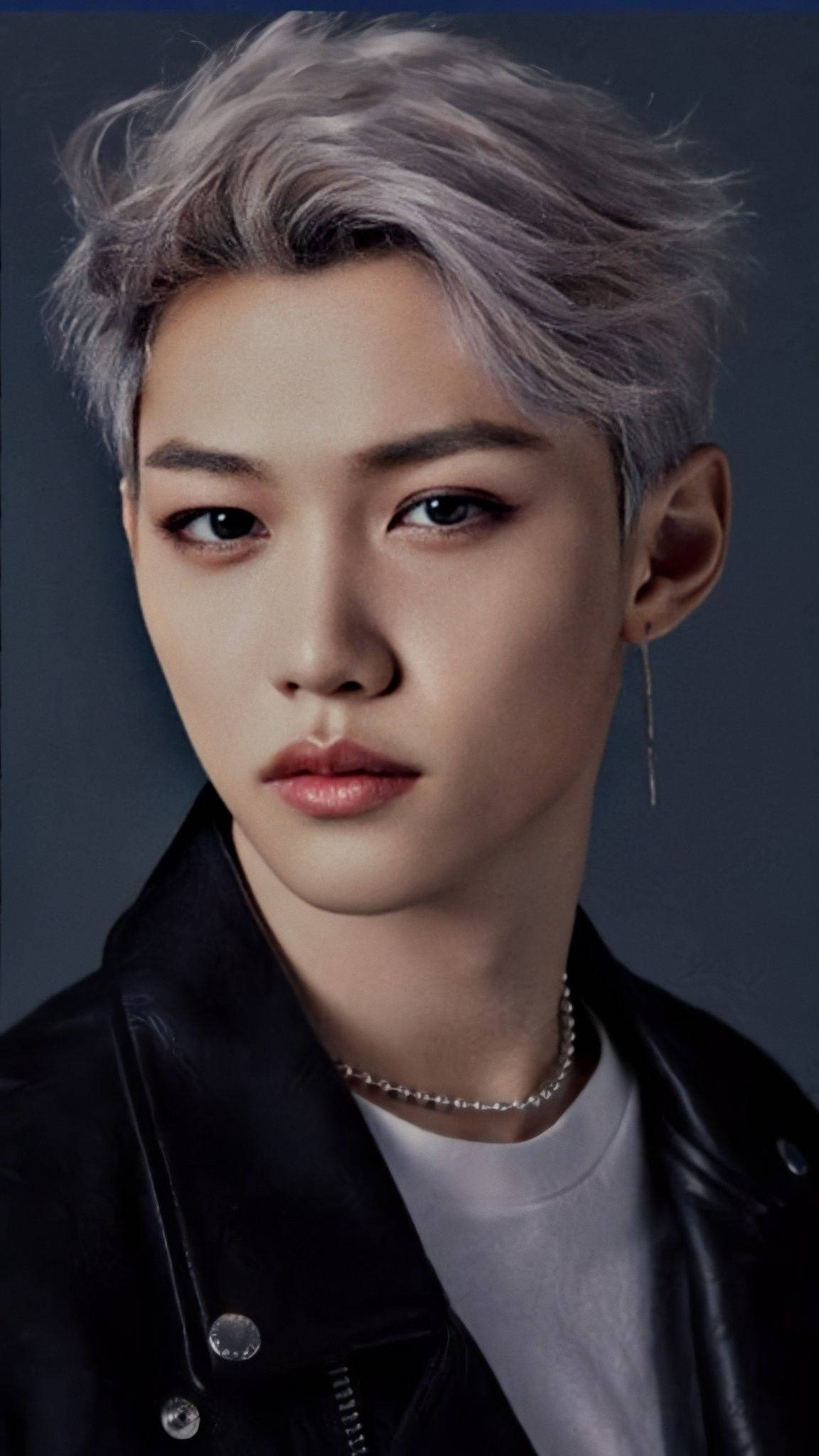 Stray Kids 桌布 壁紙 — 一位銀髮、眼神銳利的年輕男子，身穿黑色皮夾克，背景為深灰色。