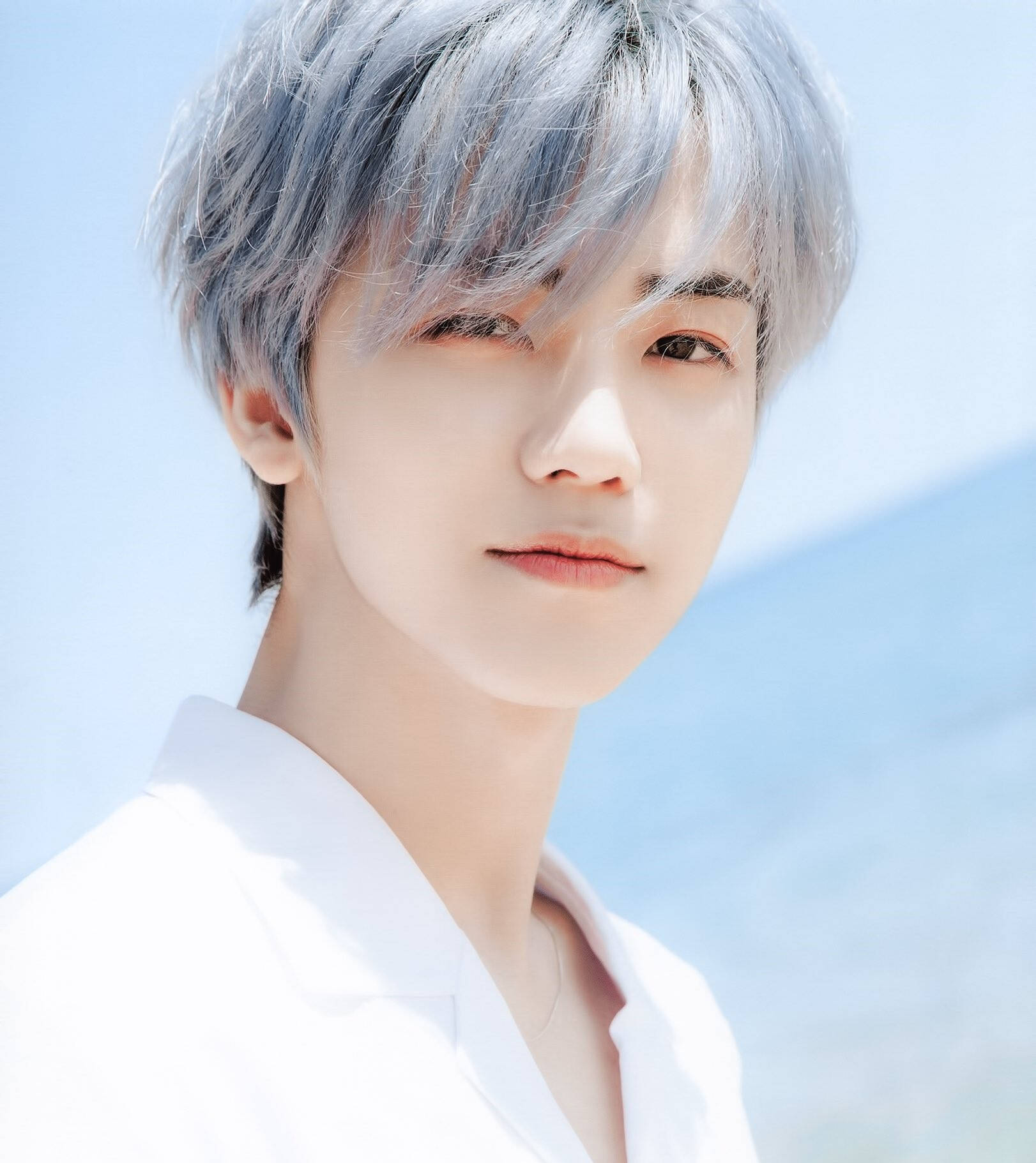 jaemin 桌布 壁紙 — 一位銀髮白衣的年輕男子，在明亮的藍天背景下溫柔凝視。