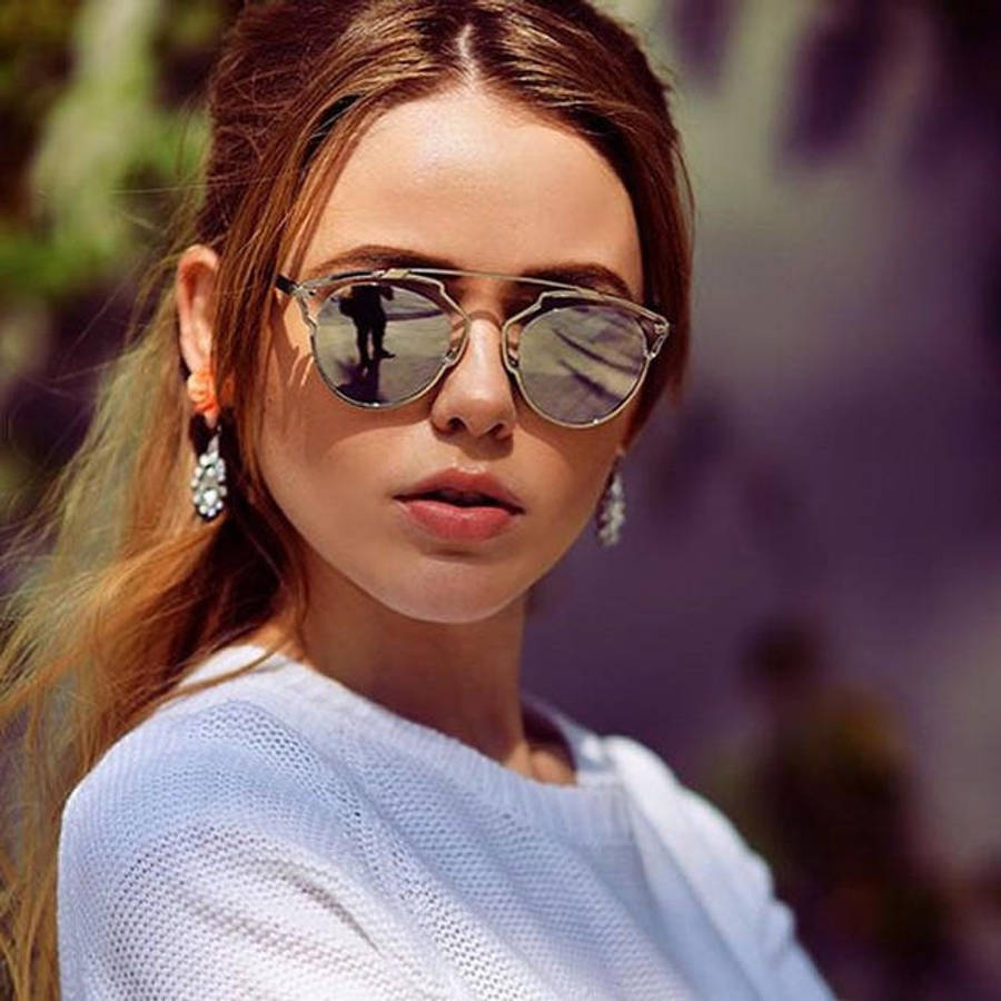 Sunglasses 桌布 壁紙 — 一位長棕色頭髮的女性在明亮的陽光下戴著時尚太陽眼鏡和淺藍色針織毛衣。