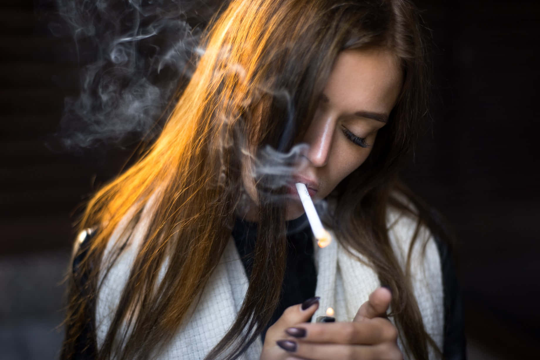 lighter 桌布 壁紙 — 一位長棕髮的女性在溫暖的金色光線中抽煙，煙霧纏繞著她的臉龐。