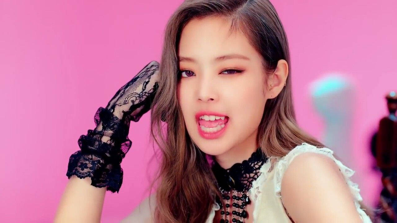 BLACKPINK 桌布 壁紙 — 一位長棕髮的年輕女性，在充滿活力的粉紅色背景前，戴著黑色蕾絲手套，穿著白色上衣。
