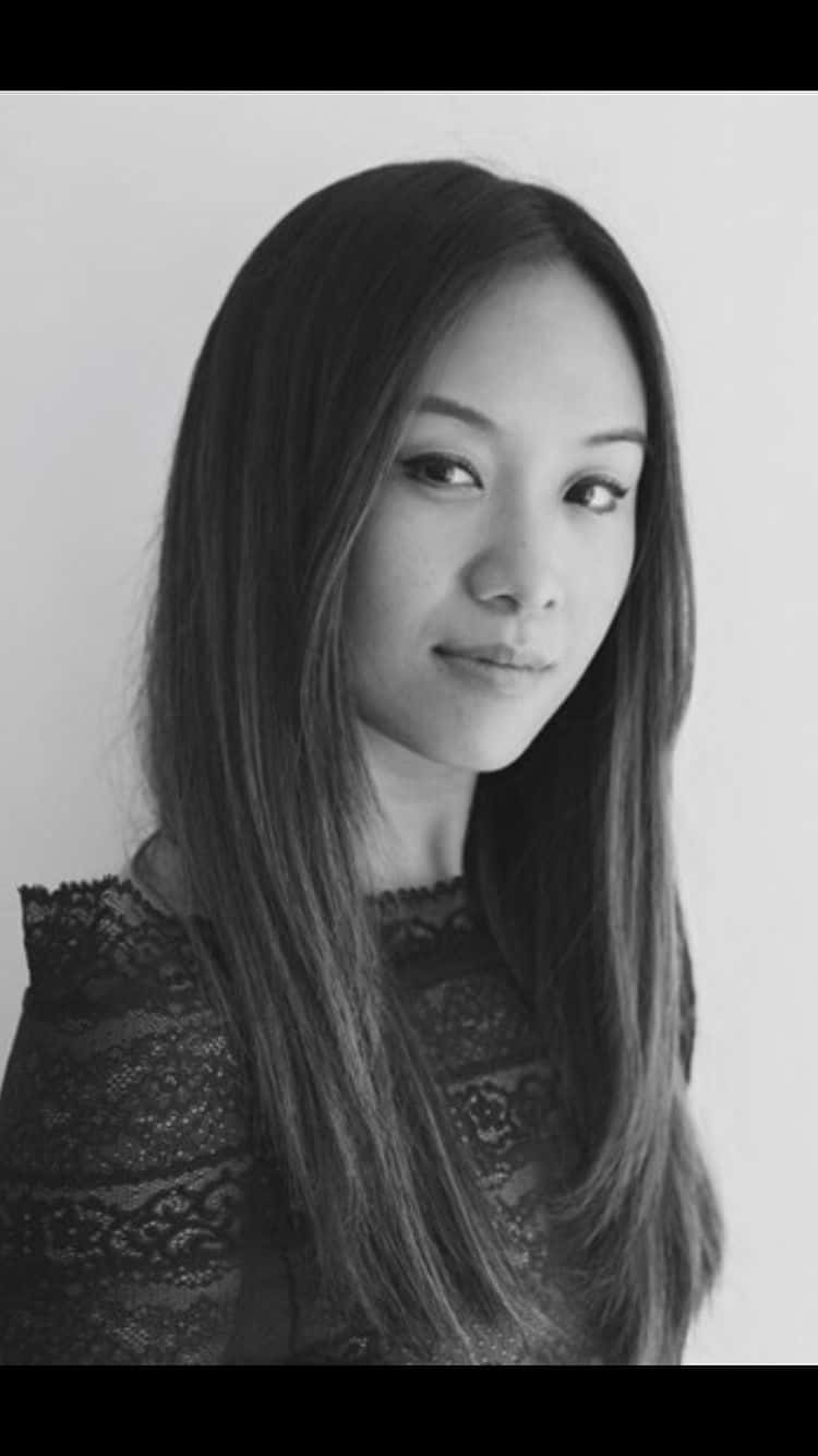 Ellen Wong 桌布 壁紙 — 一位長直髮女性穿著蕾絲上衣，在純色背景前的黑白肖像。