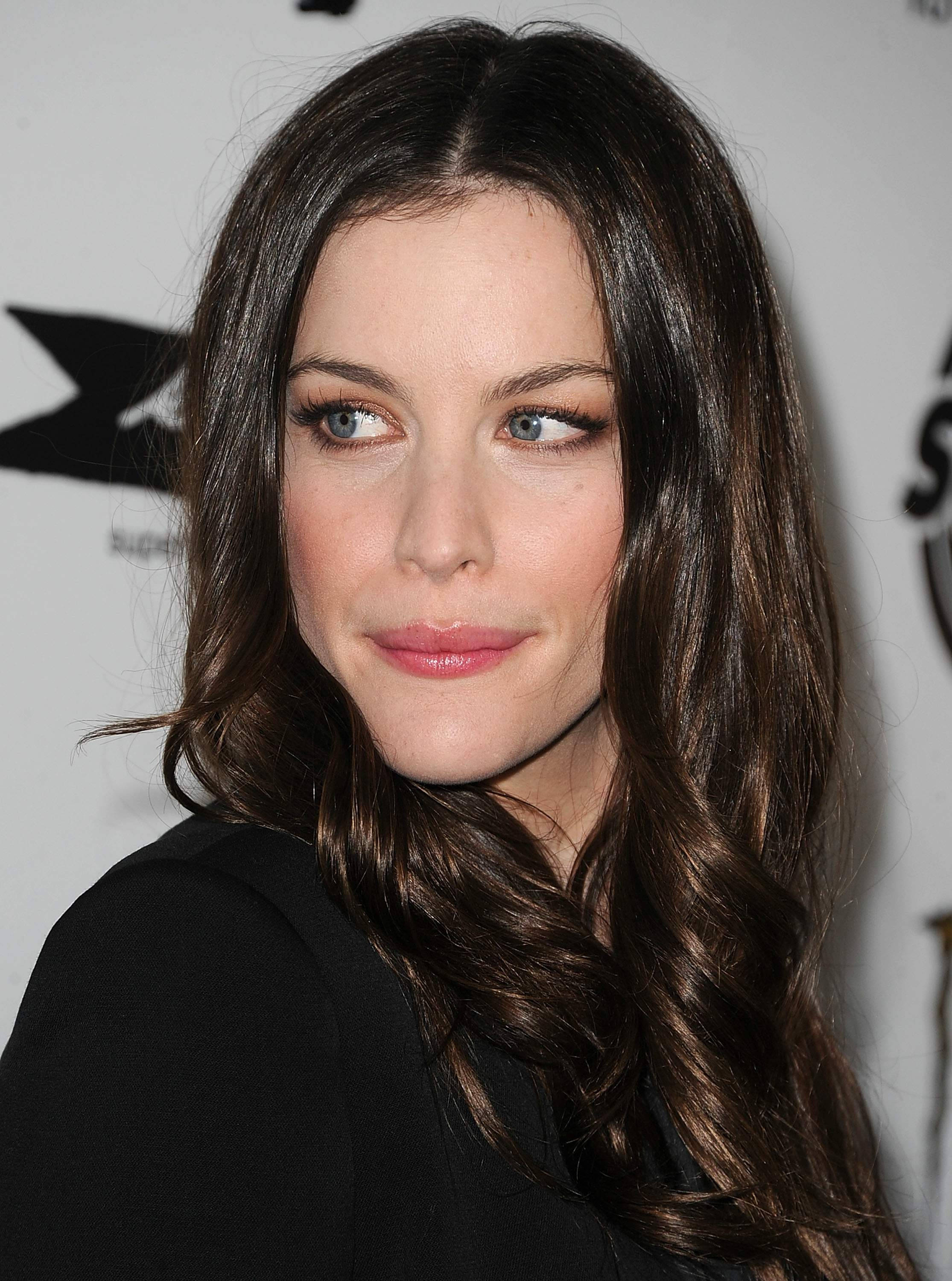 Celebrity 桌布 壁紙 — 一位長著棕色長波浪髮和藍眼睛的女性側面特寫肖像。