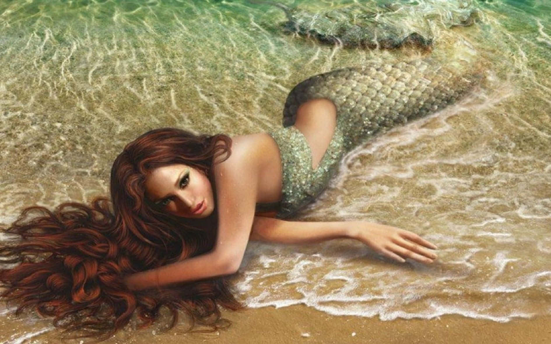 Beautiful Mermaid 桌布 壁紙 — 一位長著棕色長髮的美人魚在沙灘的淺藍綠色海水中休息。
