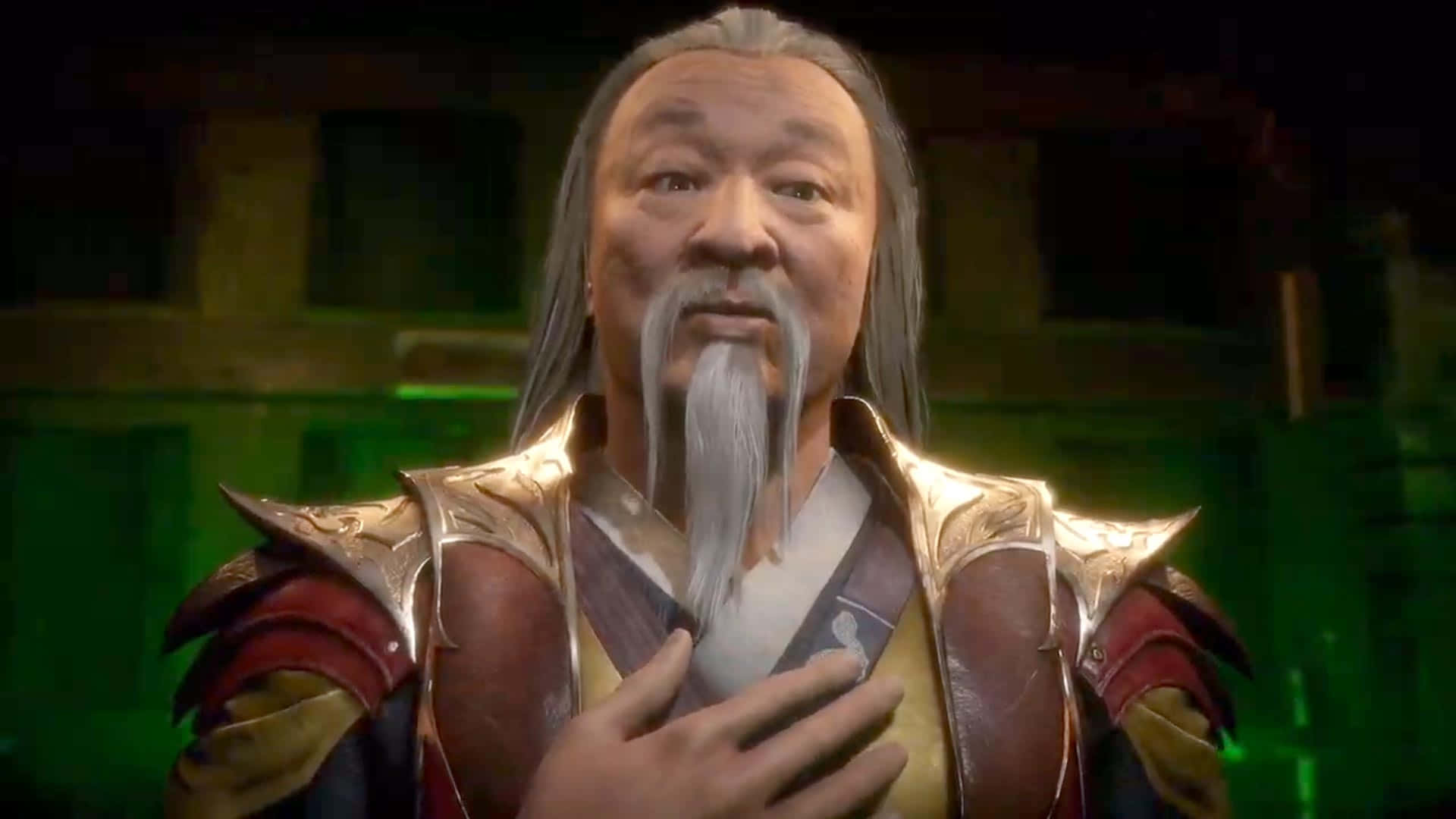 Mortal Kombat Shang Tsung 桌布 壁紙 — 一位長著白色長髮和鬍鬚的老年男子，身穿華麗的金色和紅色盔甲，在發光的綠色背景前將手放在心口上。