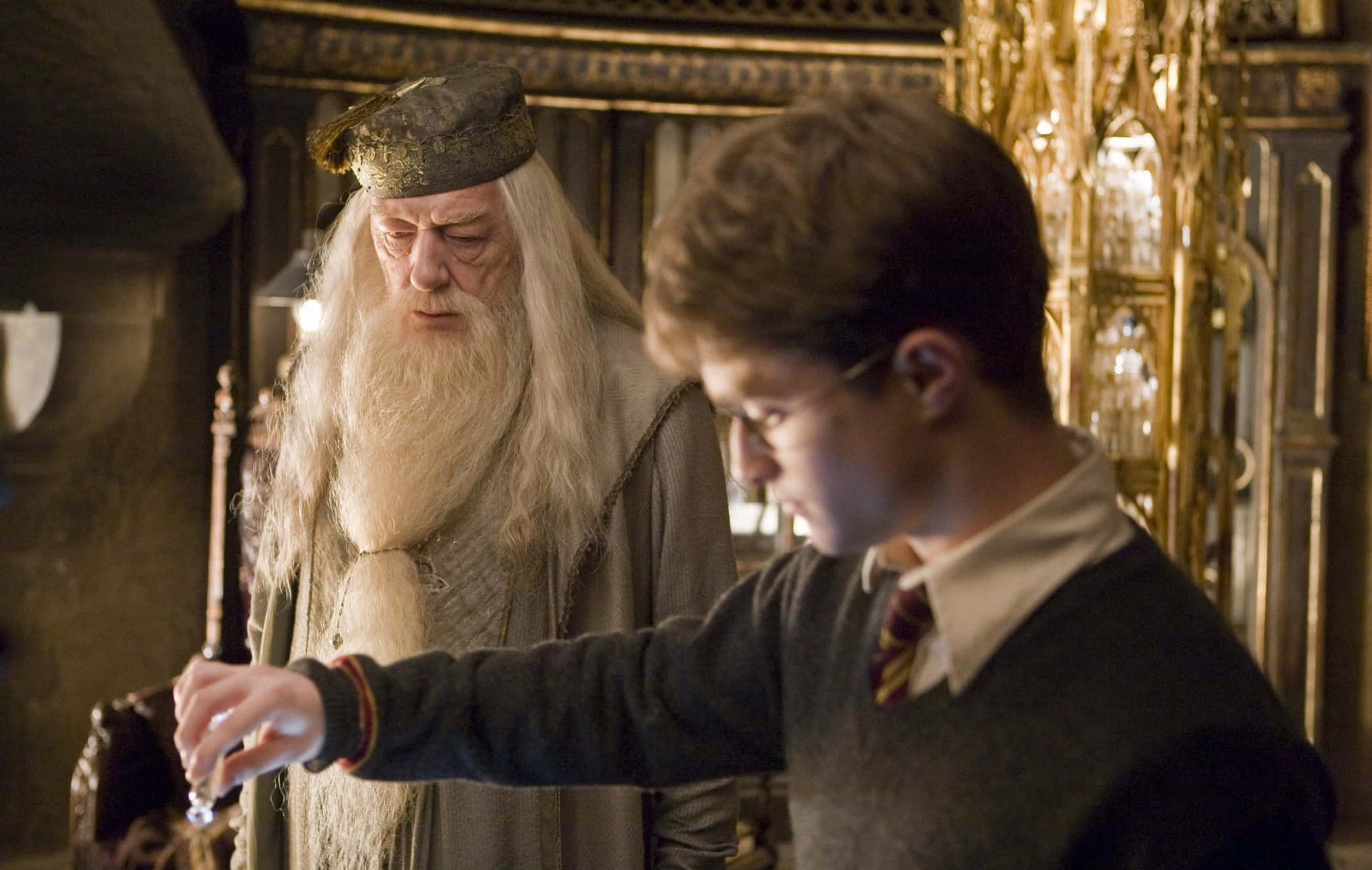 The Half-blood Prince 桌布 壁紙 — 一位長著長長白鬍鬚的老巫師專注地看著一個穿著校服的男孩做出魔法手勢。