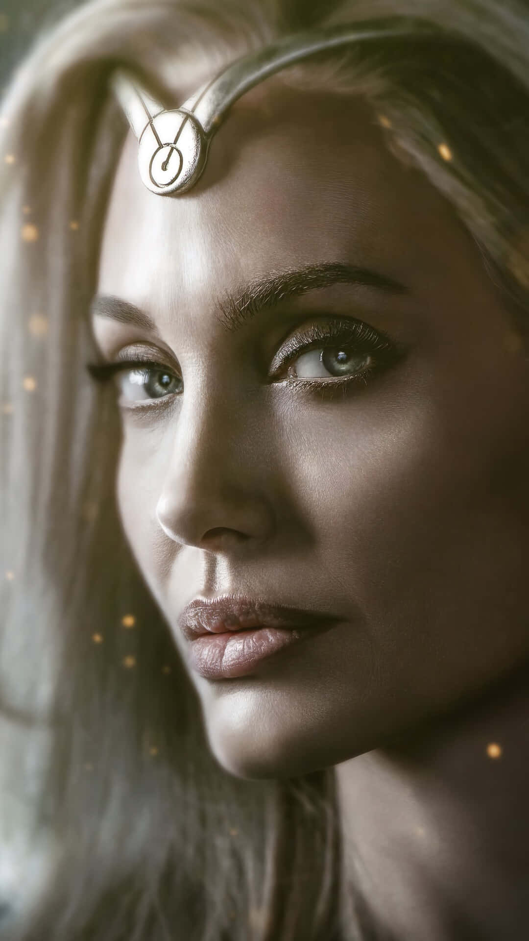 Eternals Movie 桌布 壁紙 — 一位長金髮、額頭戴銀色頭環的女子的特寫肖像，她柔和地凝視著，金色粒子在她周圍飄浮。