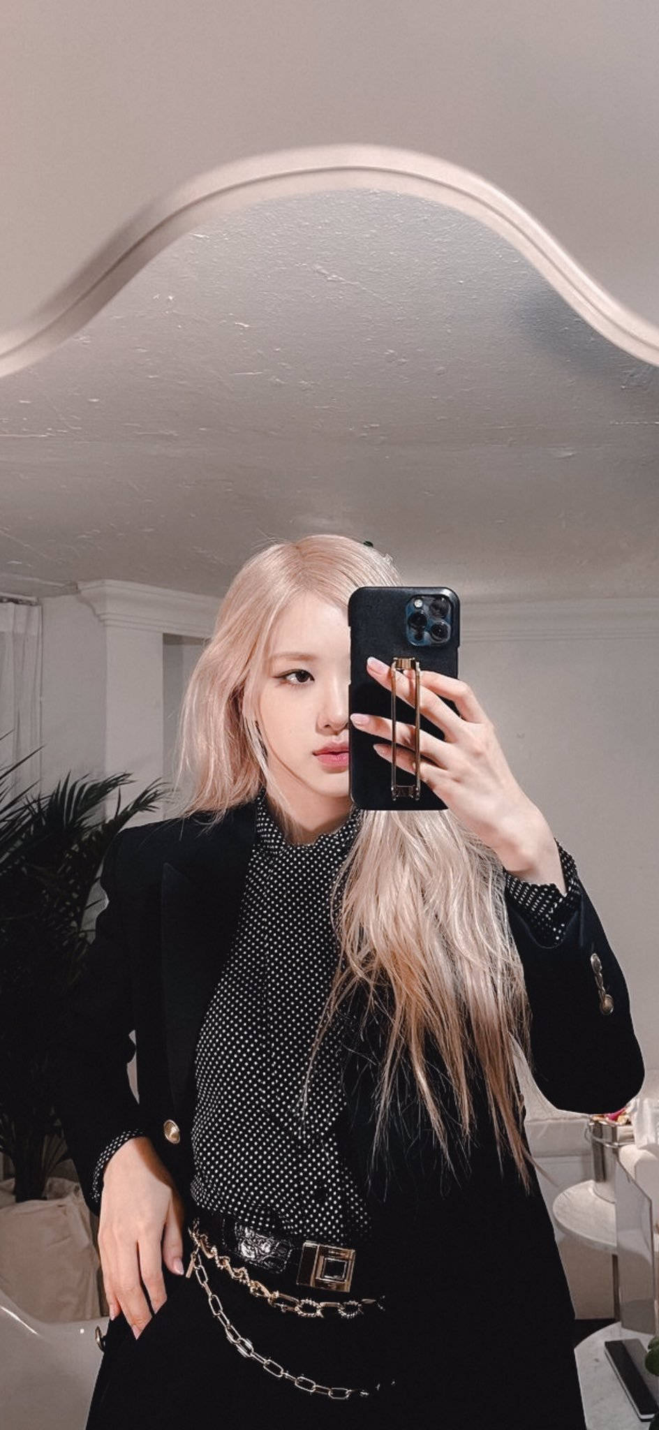 roseanne 桌布 壁紙 — 一位長金髮的人穿著黑色西裝外套和波點襯衫在室內對著鏡子自拍。
