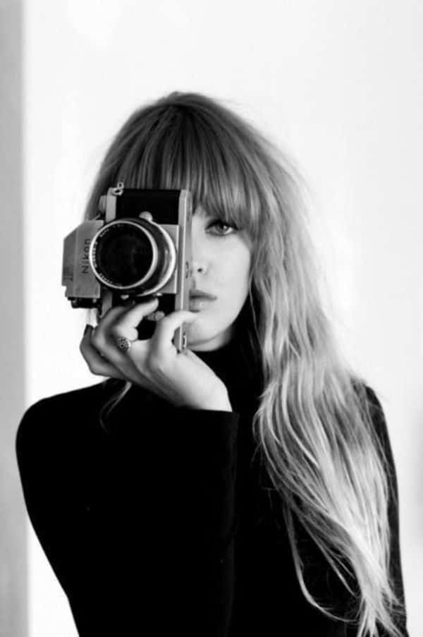 Holding Camera 桌布 壁紙 — 一位長金髮的女性將復古相機舉到臉前，拍攝了一張清晰的黑白肖像照。
