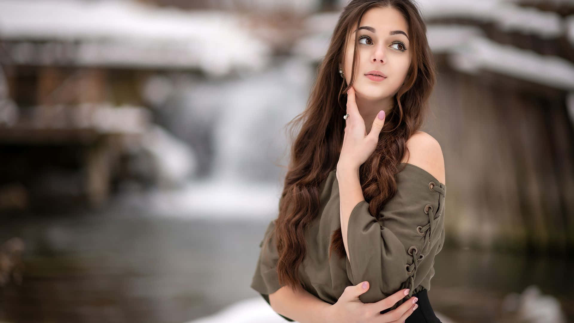 Beautiful Girls 桌布 壁紙 — 一位長長棕色頭髮的年輕女性站在被雪覆蓋的瀑布旁，帶著沉思的表情向上凝望。