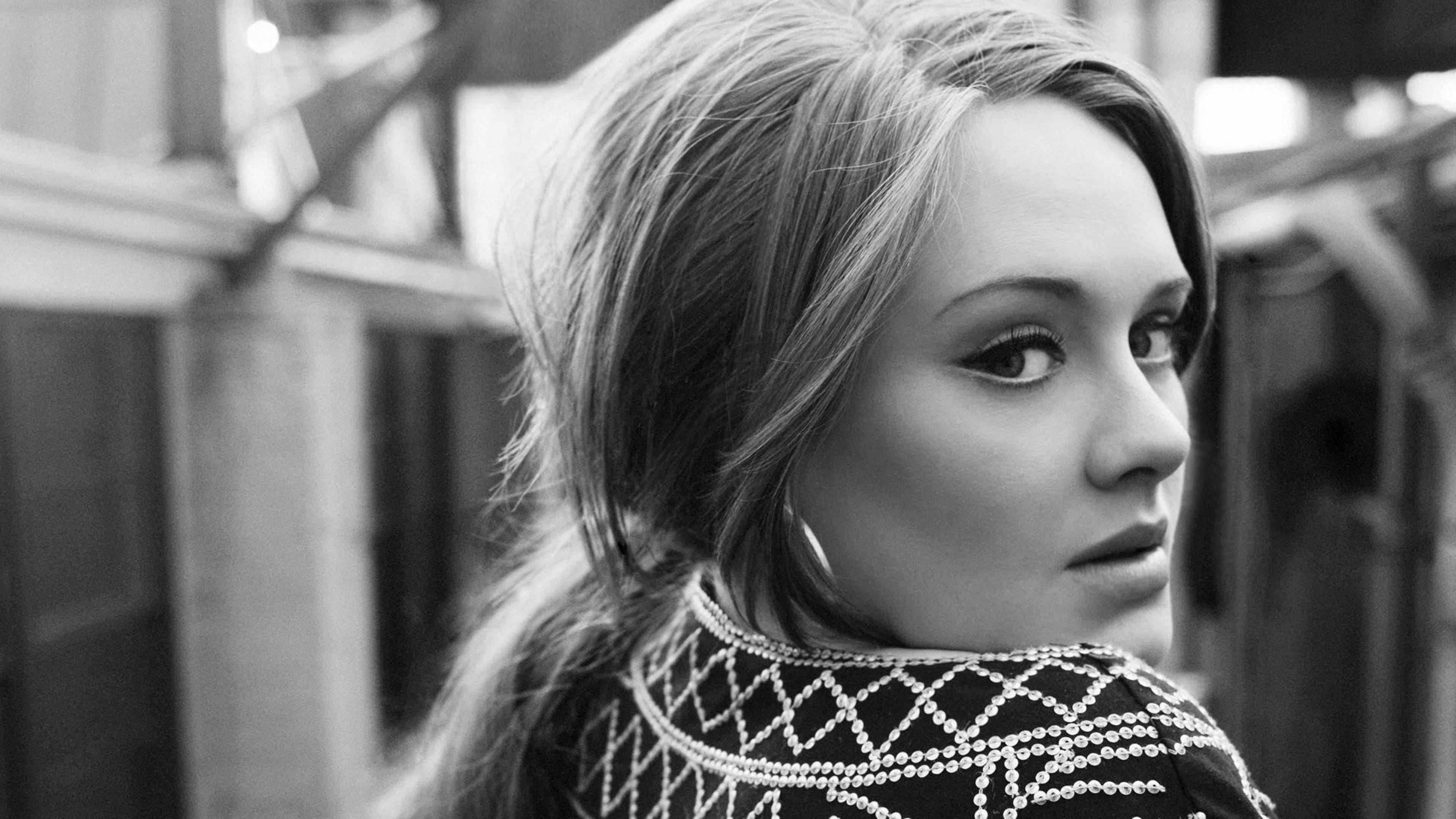 Adele 桌布 壁紙 — 一位長髮女性穿著珠飾上衣回頭望的黑白肖像。