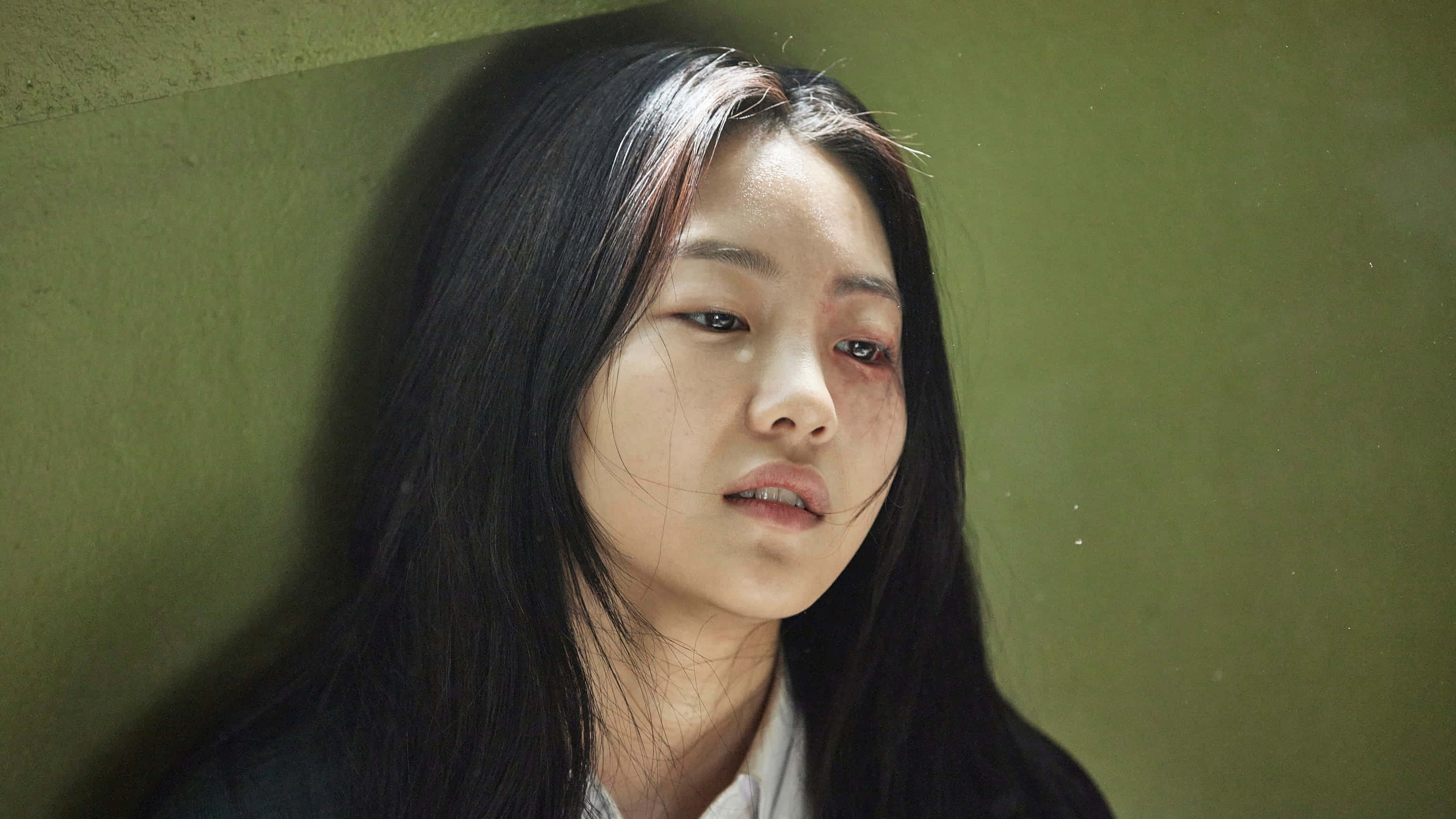 一位長髮年輕女子倚靠在牆邊 壁紙