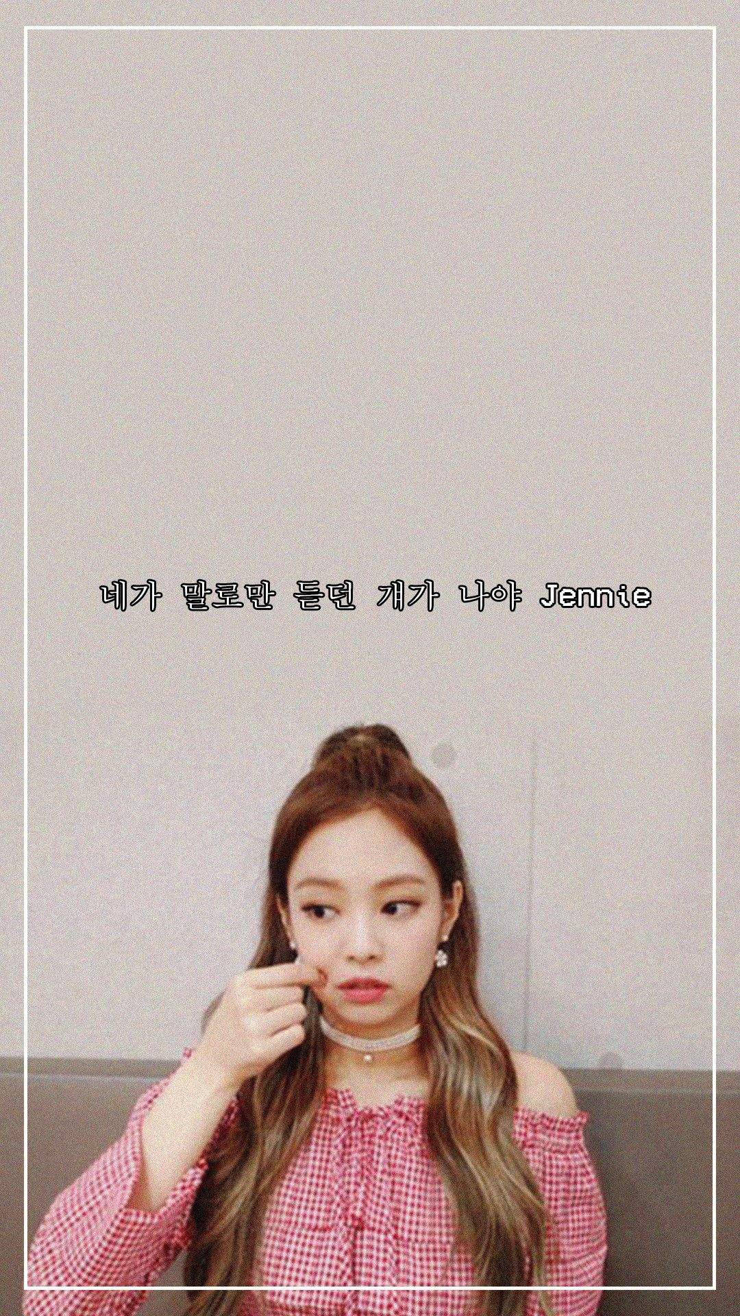 Jennie 桌布 壁紙 — 一位長髮年輕女性穿著紅色格紋上衣，在帶有韓文文字疊加的素色牆前若有所思地擺姿勢。