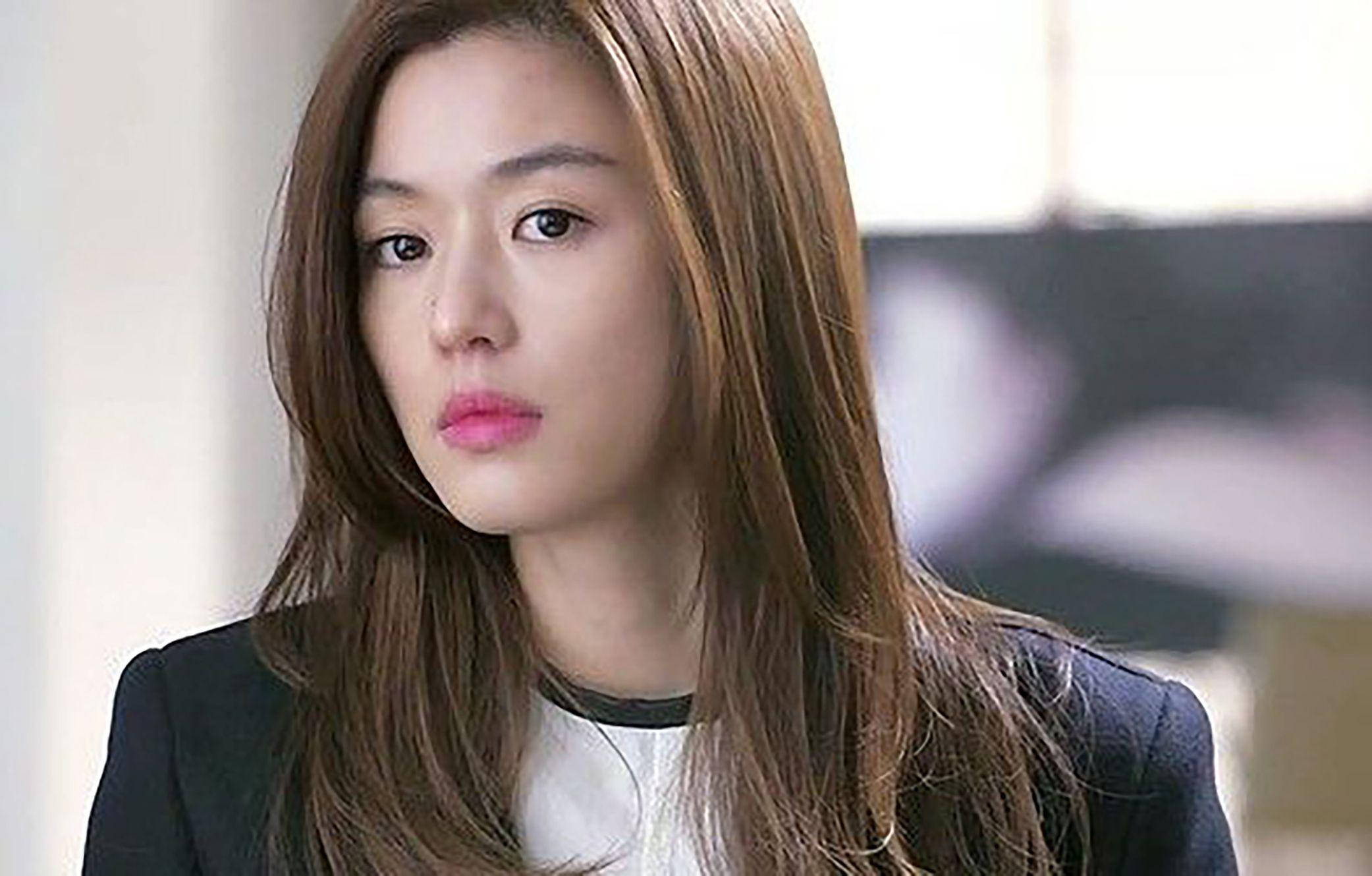 Jun Ji Hyun 桌布 壁紙 — 一位長髮棕髮女性的特寫肖像，身穿黑色西裝外套內搭白襯衫，表情嚴肅地看向鏡頭外。