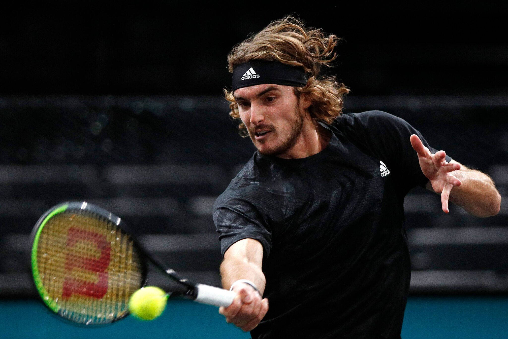 Tennis 桌布 壁紙 — 一位長髮男網球選手在明亮燈光下進行激烈比賽時揮拍擊打黃色網球。