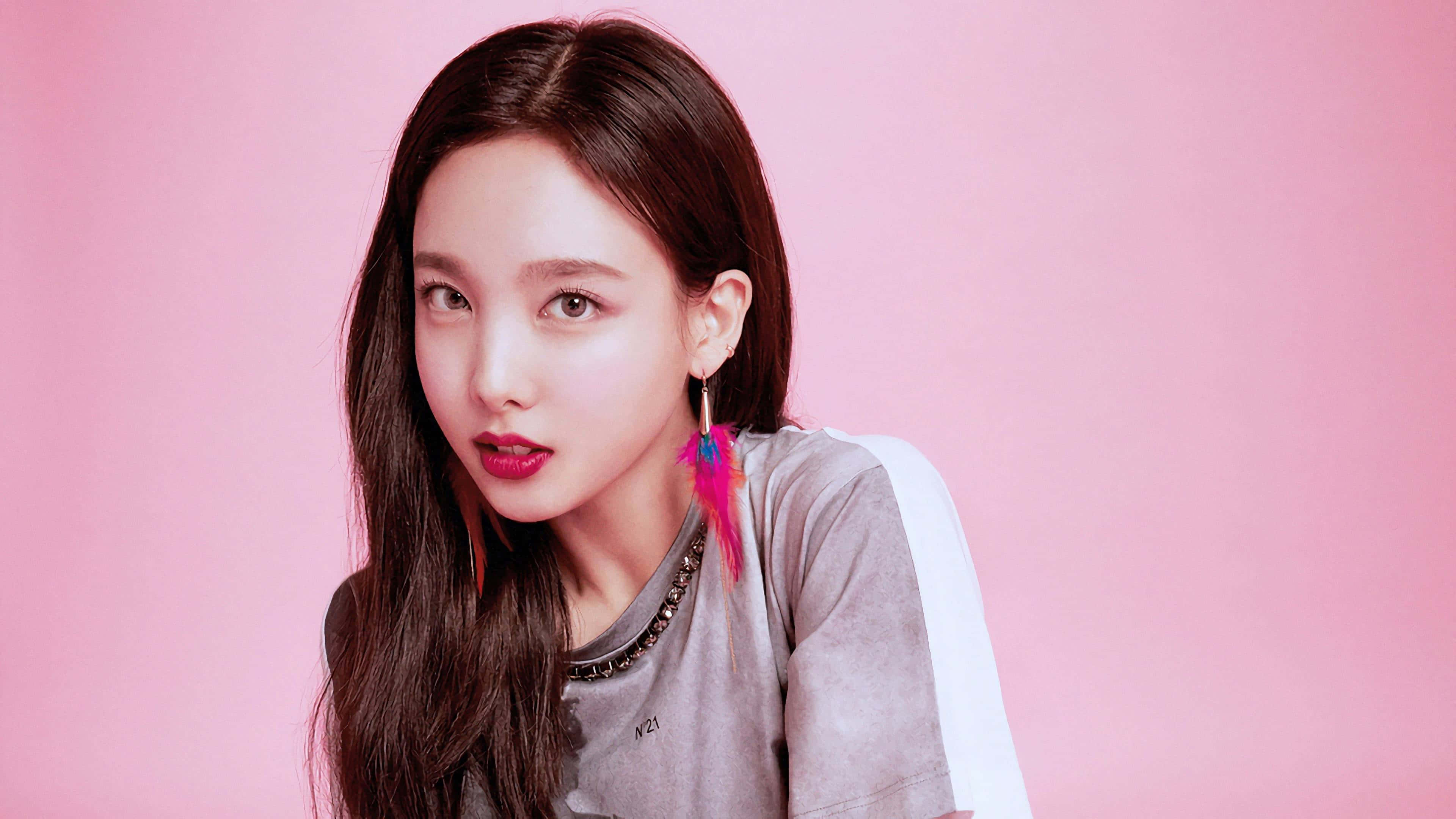 twice 桌布 壁紙 — 一位長黑髮、塗著亮粉紅色唇膏的年輕女性，在純粉紅色背景前直視鏡頭。