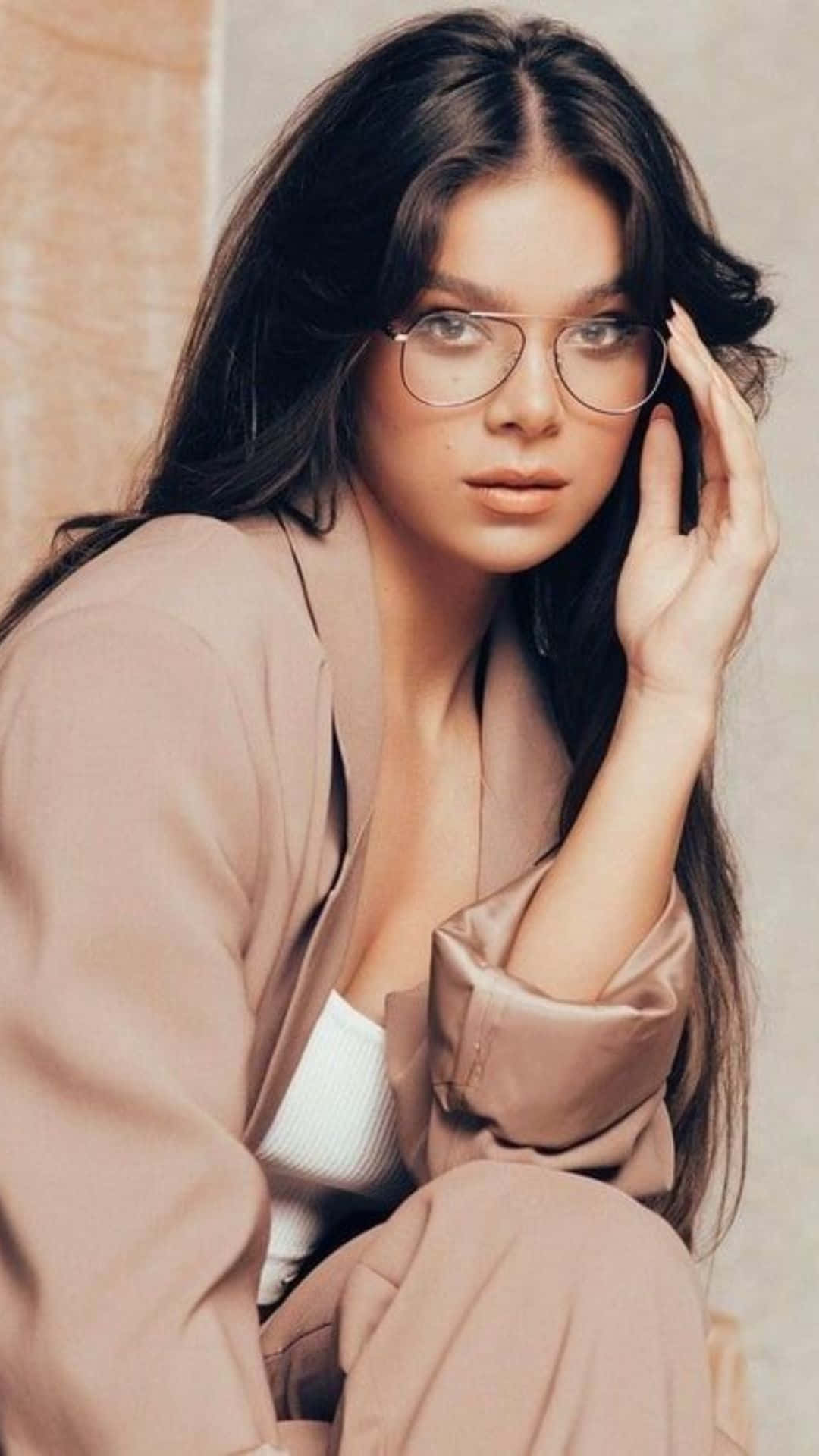 Celebrity 桌布 壁紙 — 一位長黑髮、戴圓框眼鏡的女性，穿著米色西裝外套，輕輕觸摸臉頰。