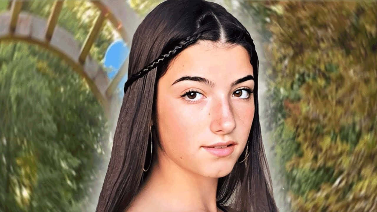 森林 桌布 壁紙 — 一位長黑髮、戴辮子頭帶的年輕女性，在模糊的花園拱門背景下溫柔地凝視。