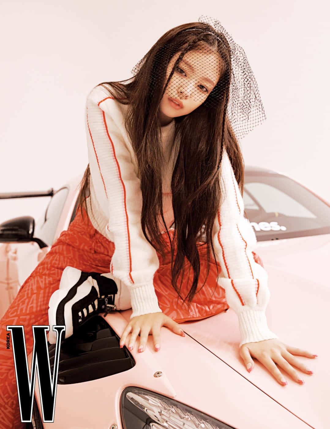BLACKPINK 桌布 壁紙 — 一位長黑髮、戴黑色面紗的女性在攝影棚內俯身於一輛粉紅色跑車上。