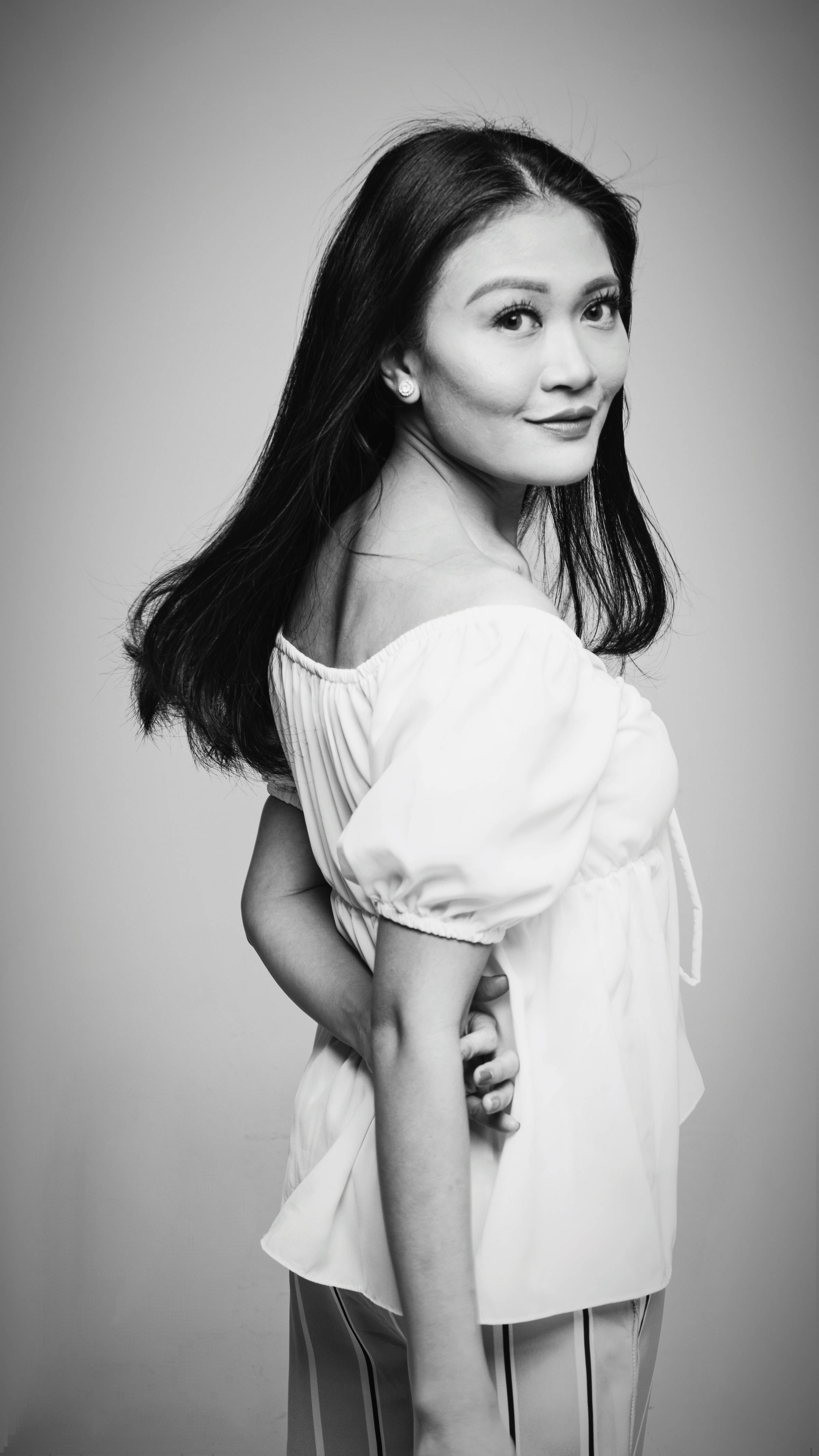 Woman 桌布 壁紙 — 一位長黑髮的女性在純灰色背景前穿著露肩襯衫，溫柔地微笑。