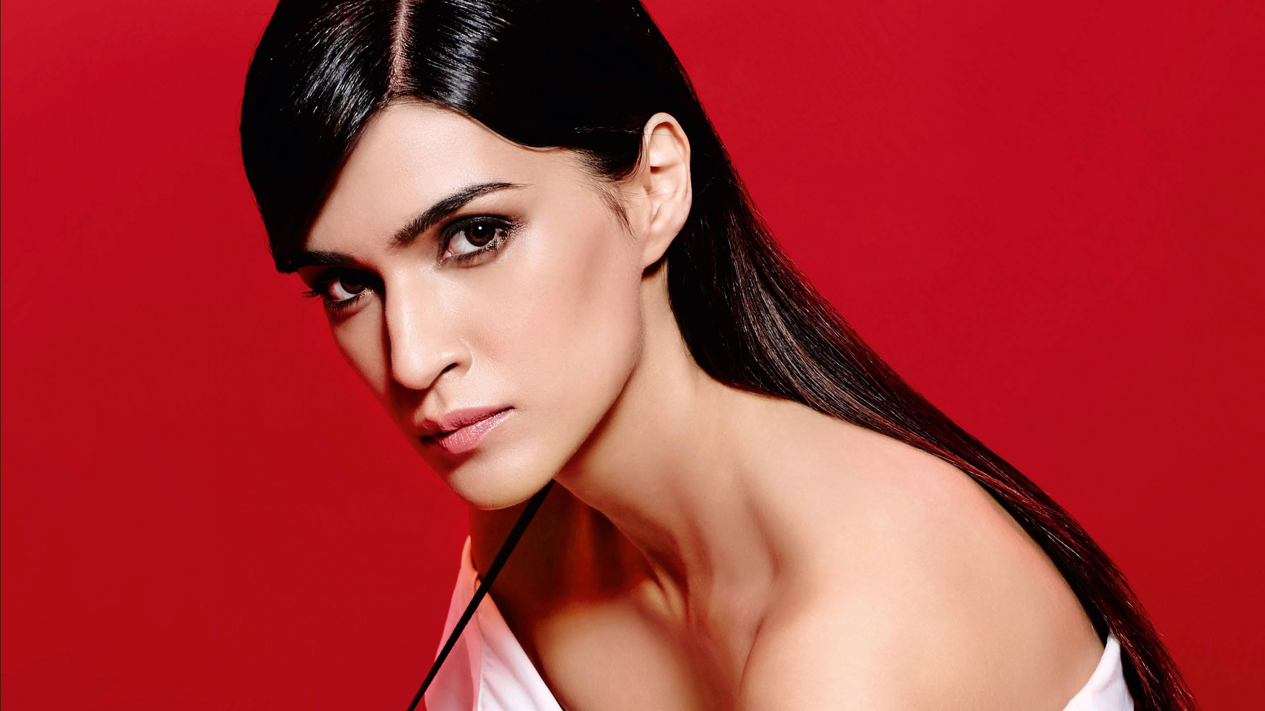 Kriti 桌布 壁紙 — 一位長黑髮的女性在鮮紅色的攝影棚背景下凝視著鏡頭。