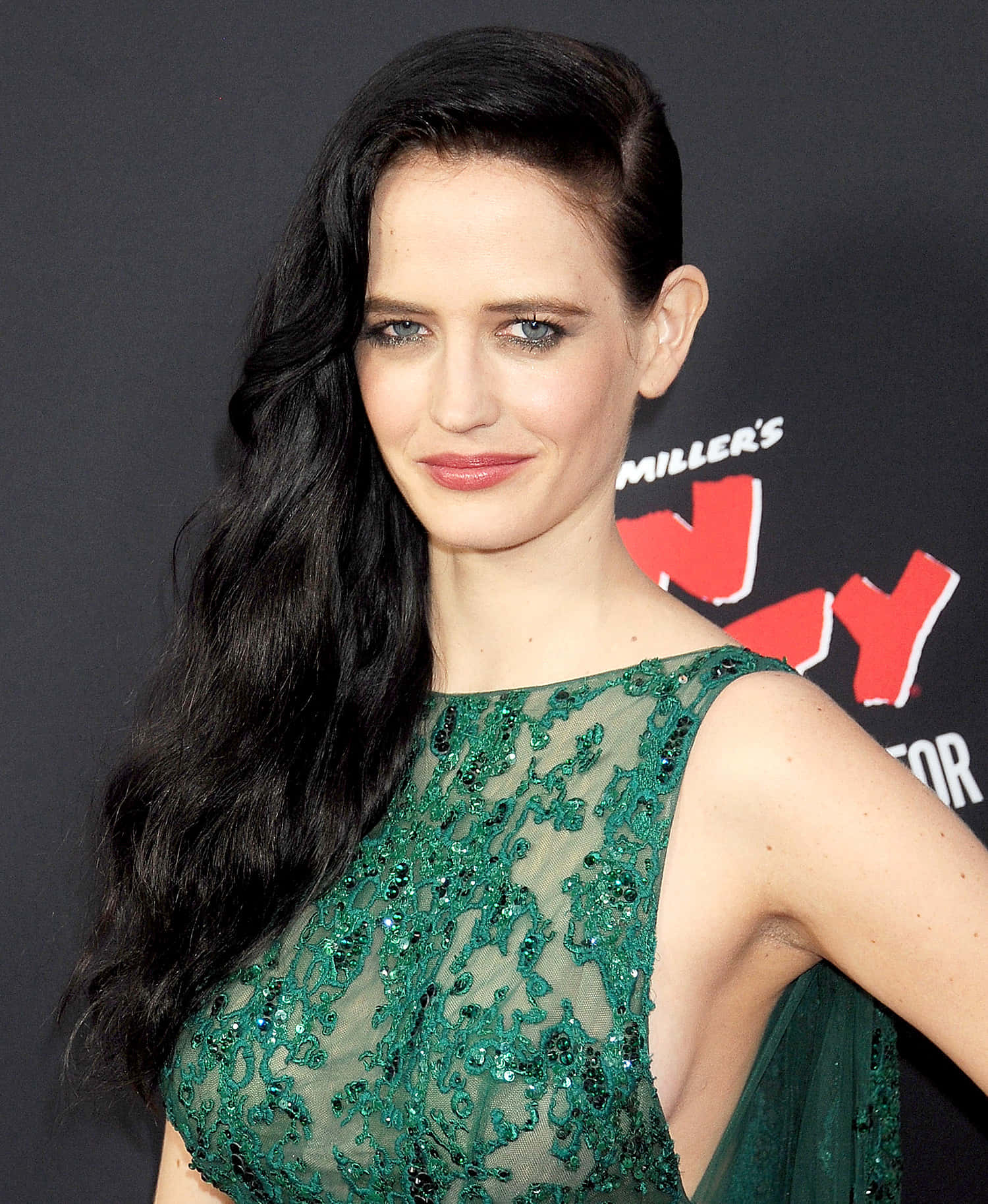 eva green 桌布 壁紙 — 一位長黑髮的女性在黑暗背景的紅地毯活動中穿著閃亮的綠色連衣裙。