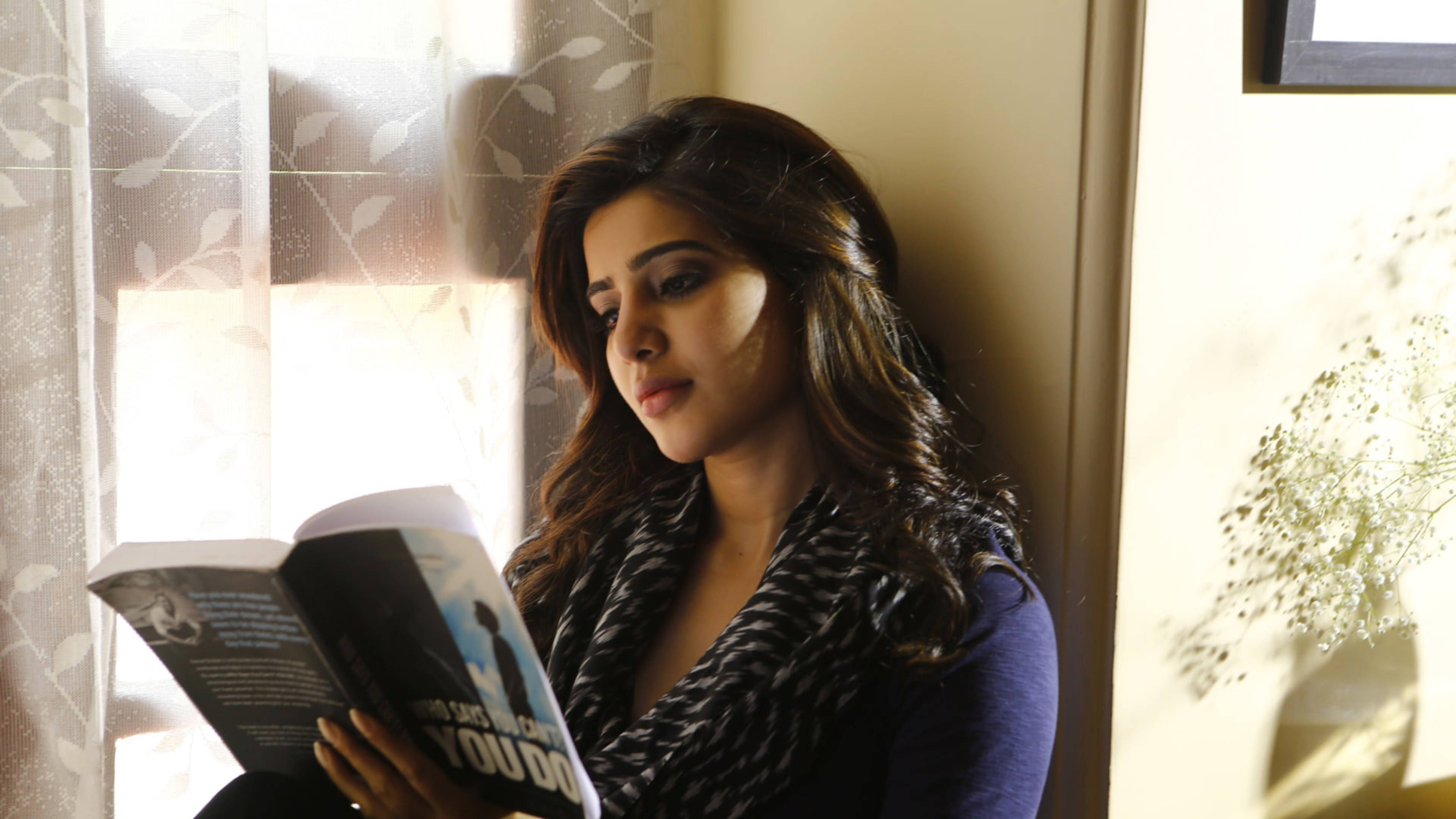 Indian 桌布 壁紙 — 一位長黑髮的女性坐在窗邊看書，柔和陽光透過圖案窗簾灑進來。
