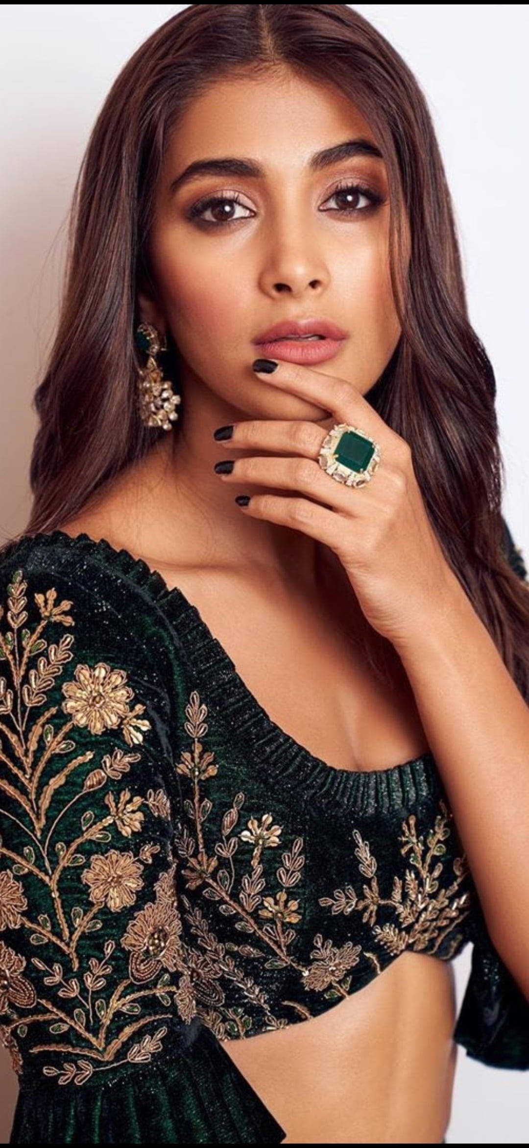 Telugu Heroines 桌布 壁紙 — 一位長黑髮的女性穿著帶有金色花卉刺繡的綠色天鵝絨上衣，佩戴著一枚大型祖母綠戒指和相配的耳環擺姿勢。