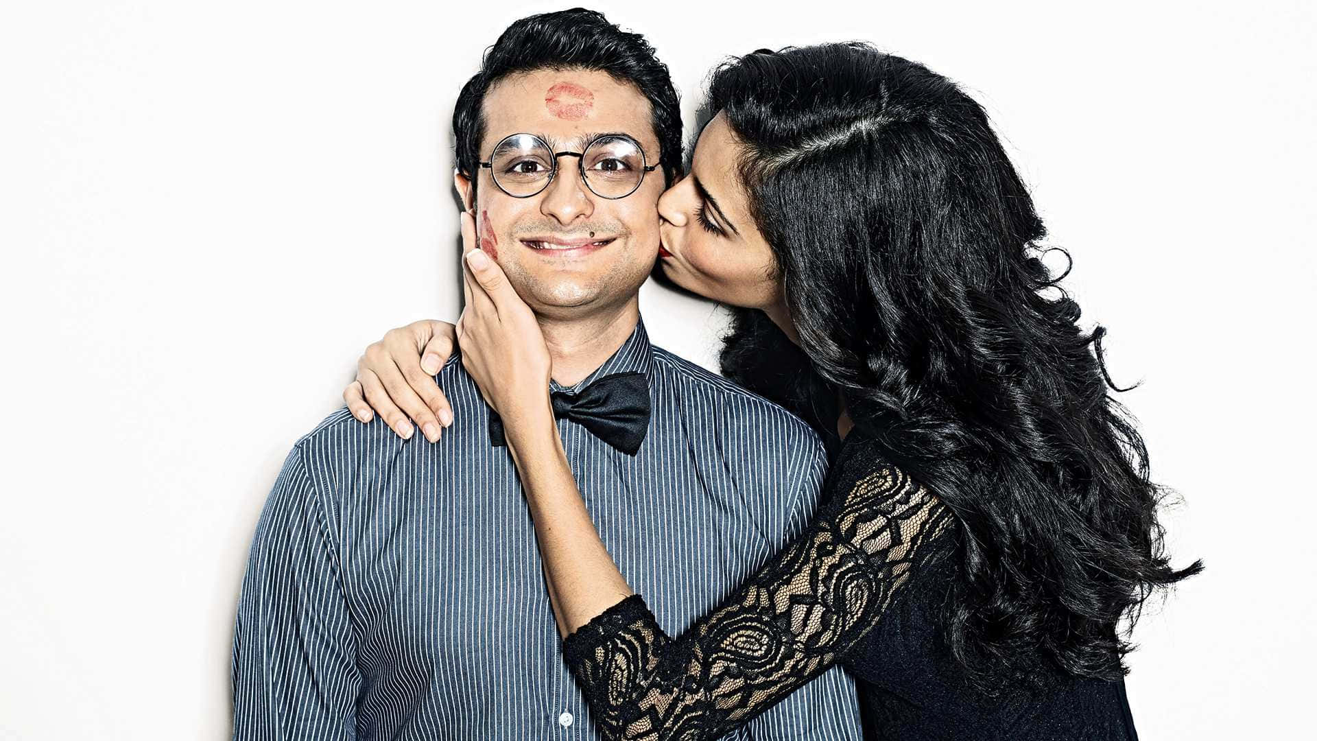 Indian 桌布 壁紙 — 一位長黑髮的女性輕輕捧著一位微笑男士的臉頰，在純白背景前親吻他的臉頰。
