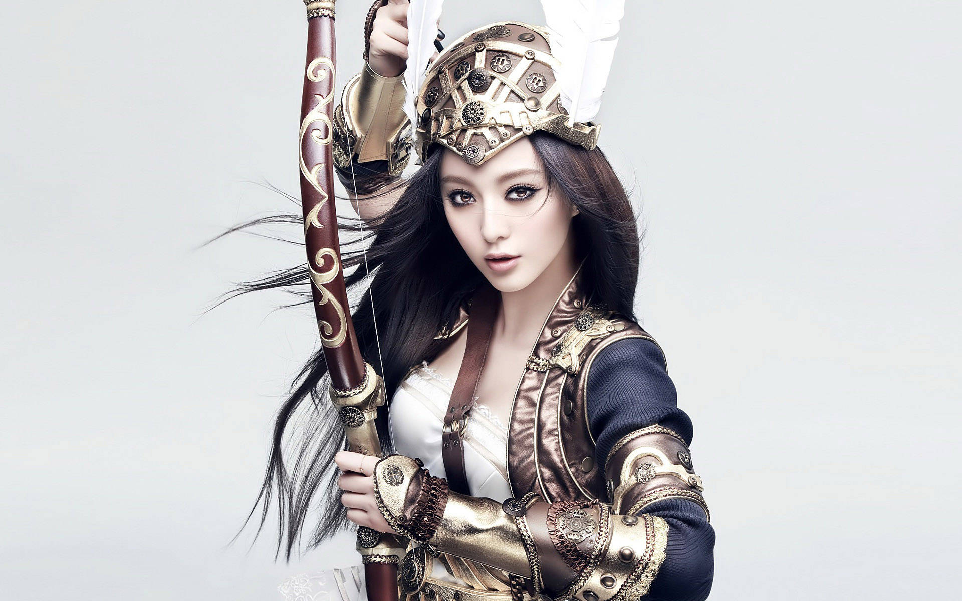 Warrior 桌布 壁紙 — 一位長黑髮的女戰士手持裝飾弓和箭，身穿華麗的金色盔甲，背景為純白色。