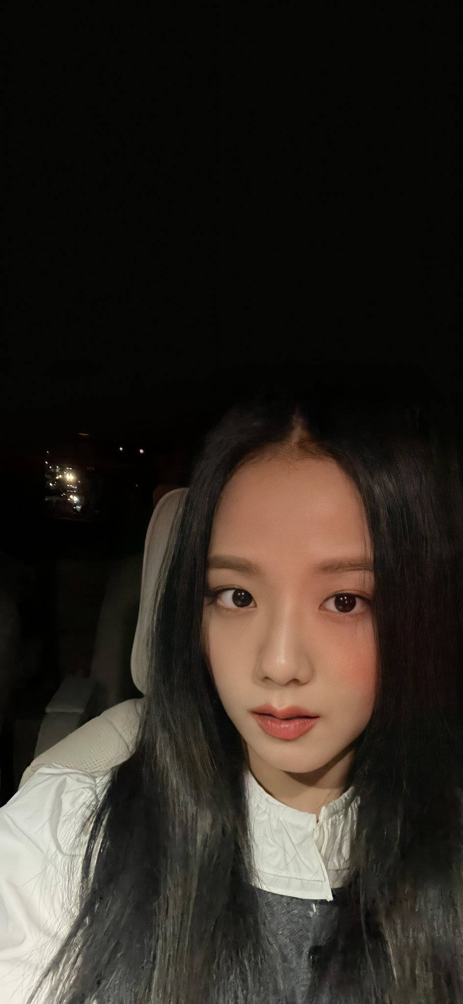 jisoo 可愛 桌布 壁紙 — 一位長黑髮的年輕女性在夜間光線昏暗的車內直視鏡頭。