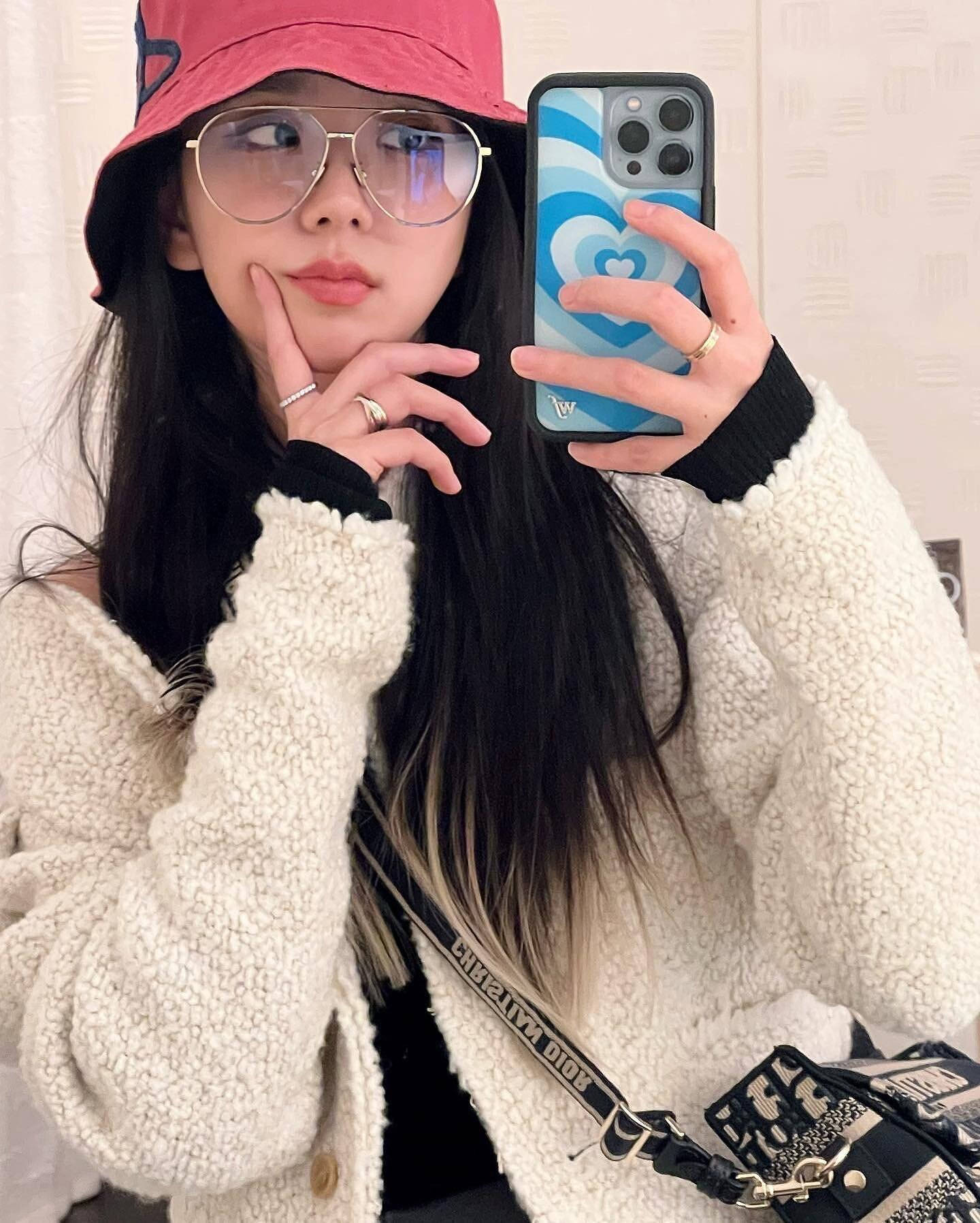 jisoo 可愛 桌布 壁紙 — 一位長黑髮的年輕女性戴著粉紅色漁夫帽和大框眼鏡，穿著舒適的白色絨毛外套對著鏡子自拍。