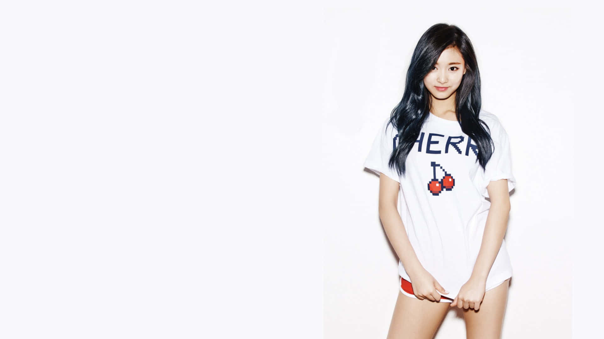 twice 桌布 壁紙 — 一位長黑髮的年輕女性穿著帶有像素化櫻桃圖案的白色T恤，站在純白色背景前。