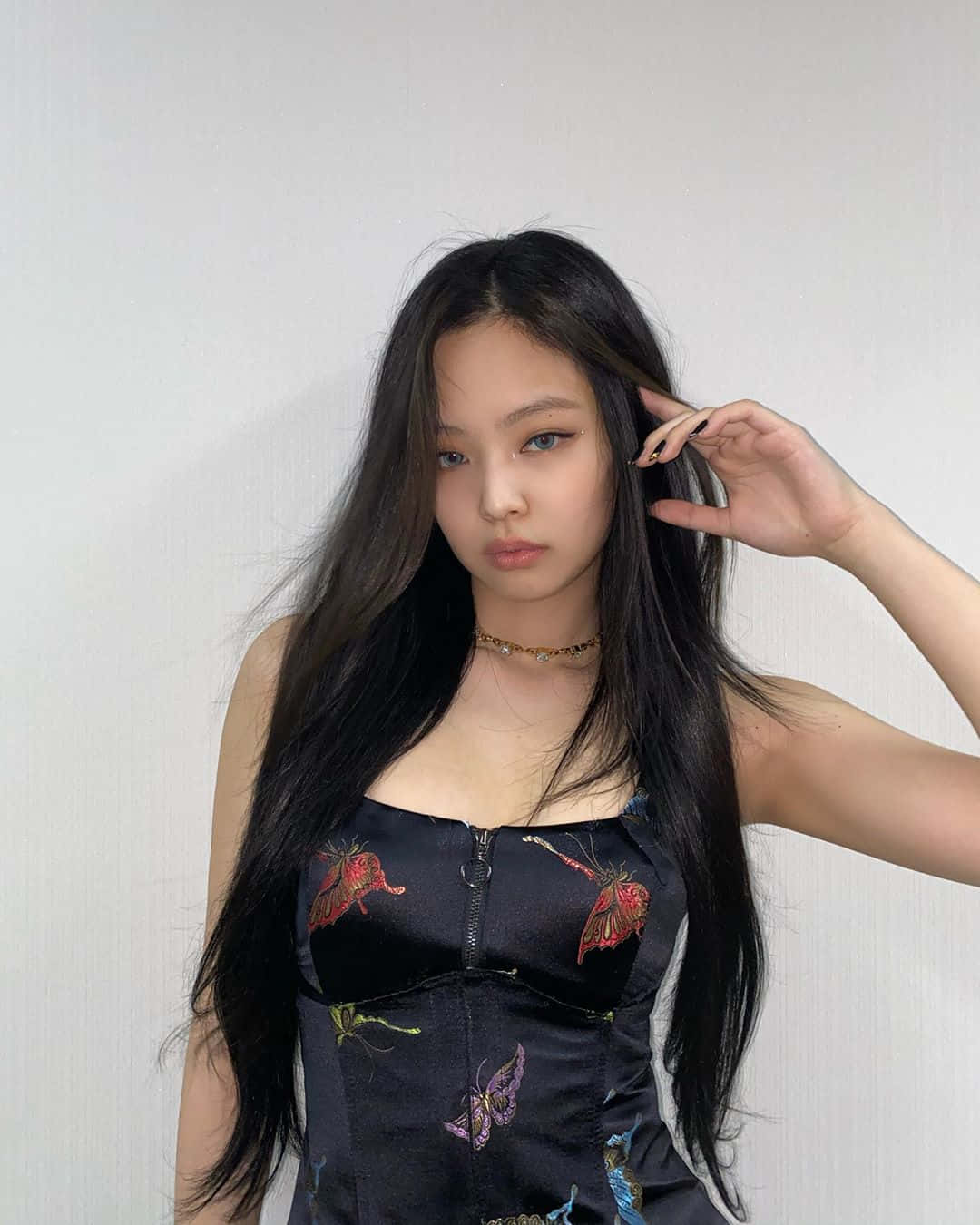 BLACKPINK 桌布 壁紙 — 一位長黑髮的年輕女性穿著黑色蝴蝶圖案上衣，背景是純白牆壁。