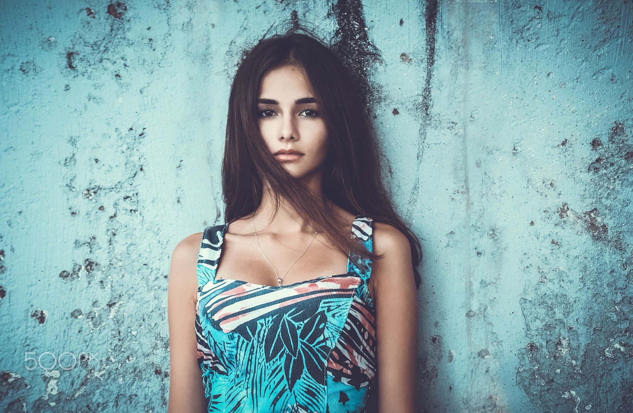 Woman 桌布 壁紙 — 一位長黑髮的年輕女性靠著風化的藍色牆壁，身穿熱帶圖案上衣。