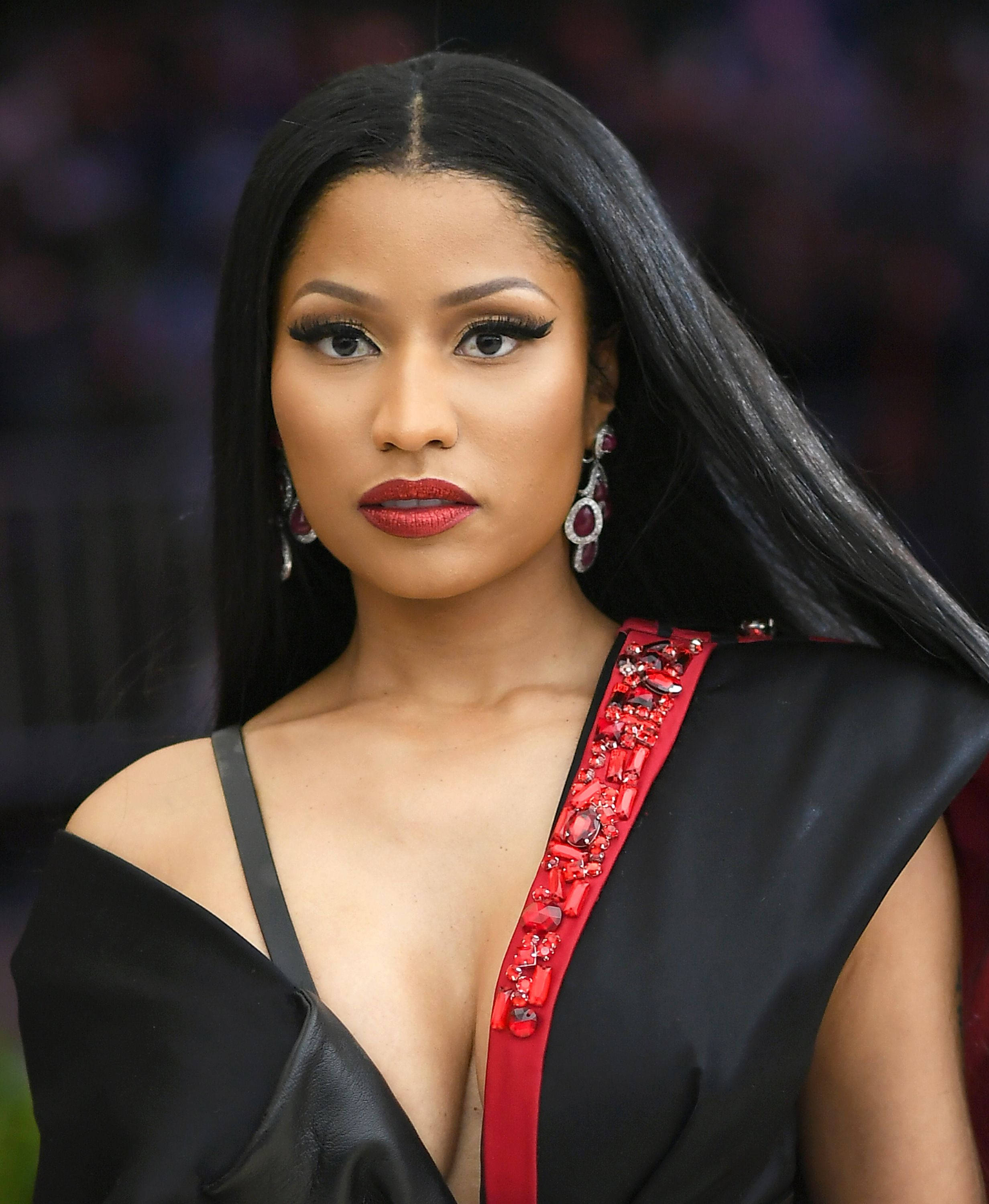 Nicki 桌布 壁紙 — 一位長黑髮的迷人女性穿著帶有紅色珠飾邊的黑色連衣裙和鮮豔的紅色唇膏。
