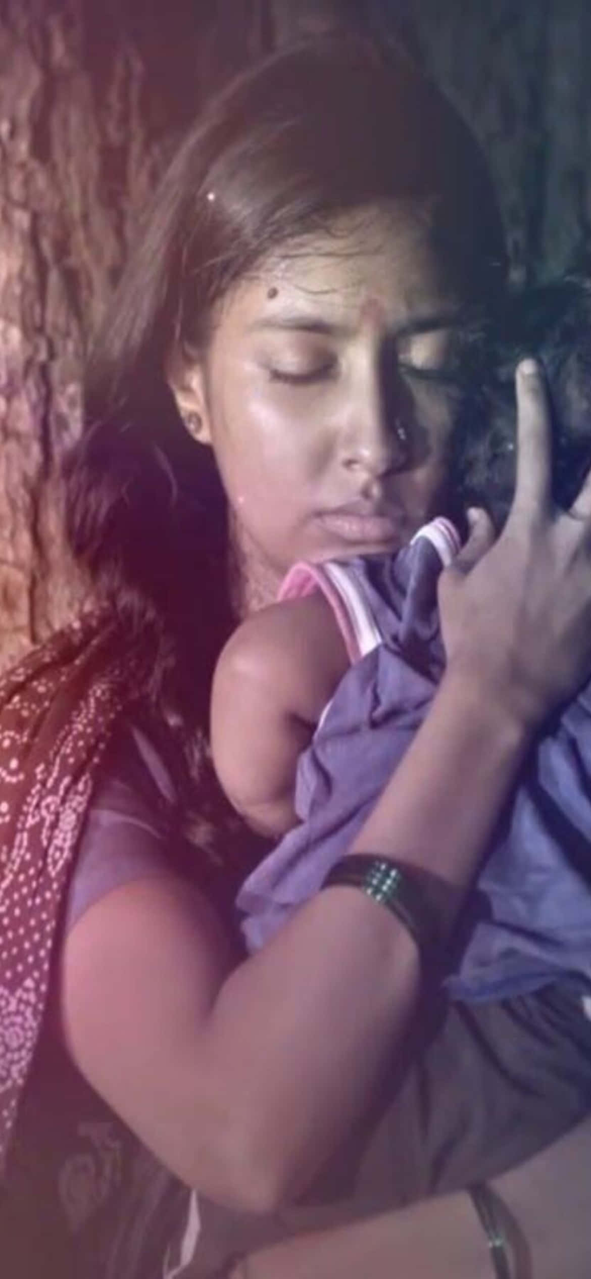 mother 桌布 壁紙 — 一位閉著眼睛的女性在昏暗溫暖的光線中，輕輕地將嬰兒抱在紋理樹幹旁。