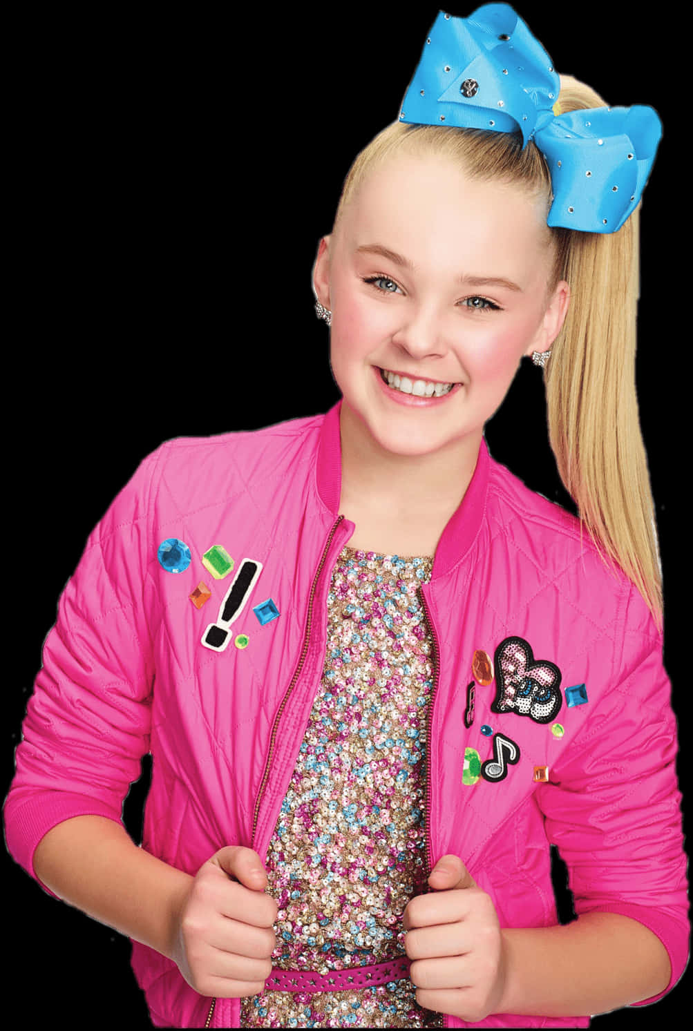 JoJo Siwa 桌布 壁紙 — 一位開朗的年輕女孩，金色頭髮紮成高馬尾，身穿亮粉紅色炸彈外套，飾有彩色寶石，頭上戴著一個大藍色蝴蝶結。