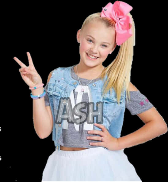 JoJo Siwa 桌布 壁紙 — 一位開朗的金髮小女孩戴著粉紅色蝴蝶結，穿著牛仔外套和白色裙子，微笑著比出和平手勢。