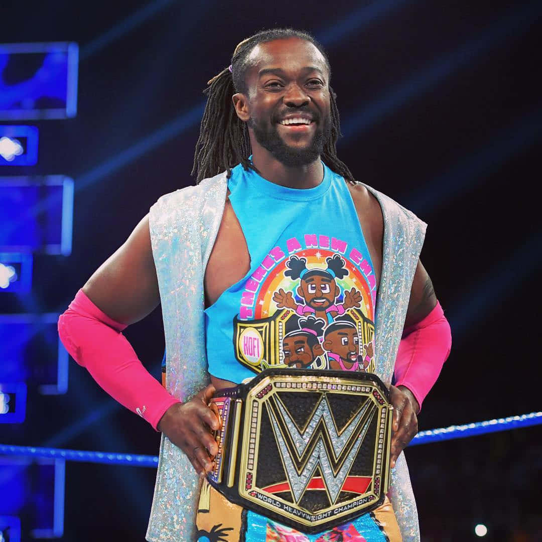 WWE 桌布 壁紙 — 一位面帶微笑、留著辮子的摔角手在燈光明亮的擂台上自豪地舉起WWE世界重量級冠軍腰帶。