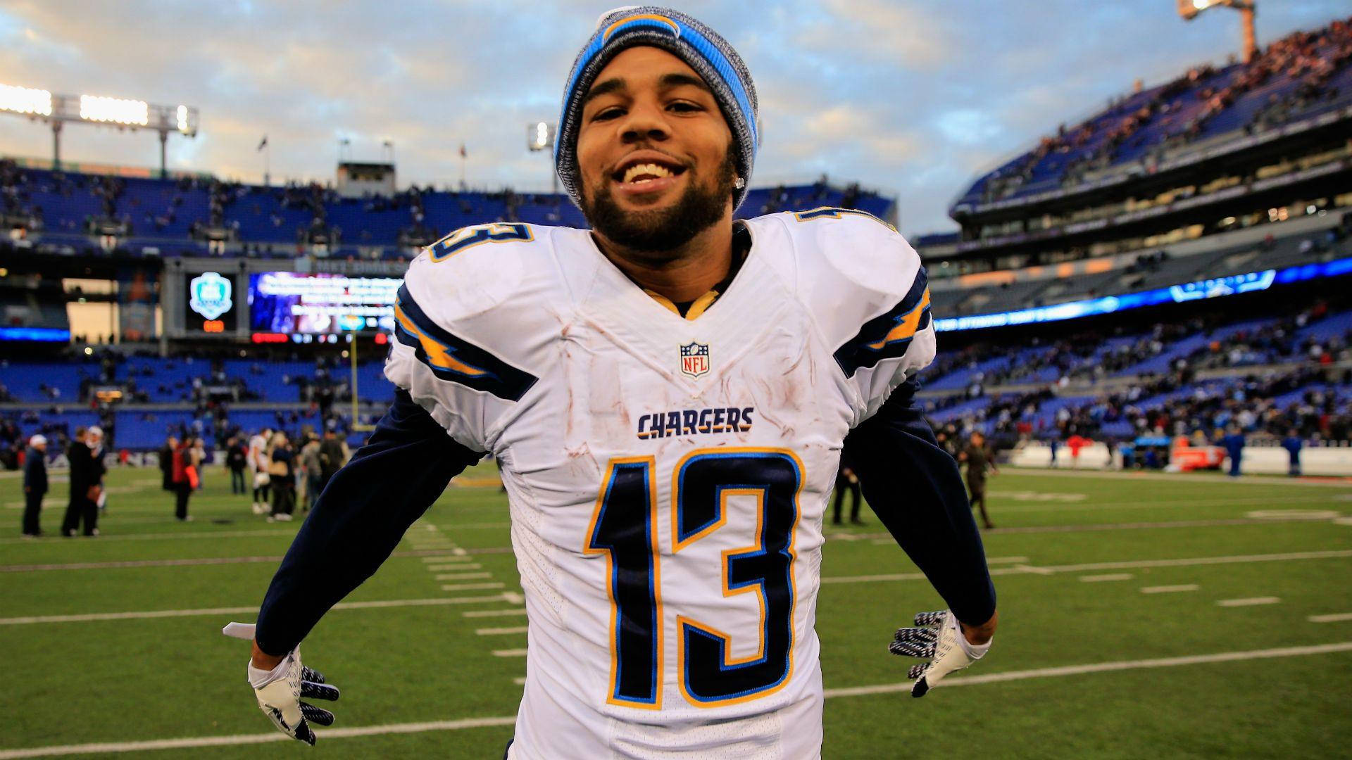 運動 桌布 壁紙 — 一位面帶微笑的NFL球員身穿Chargers球衣，在黃昏的球場上與看台上的球迷一起慶祝。