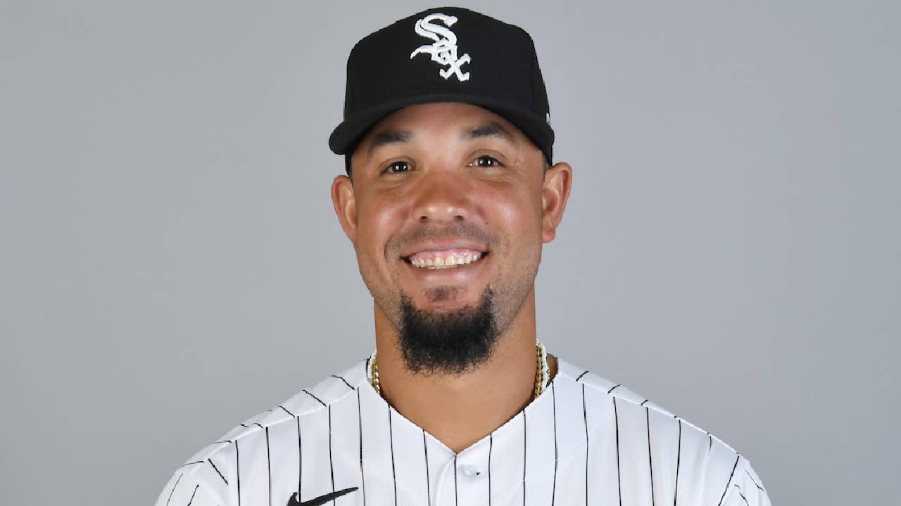 jose abreu 桌布 壁紙 — 一位面帶微笑的棒球運動員身穿芝加哥白襪隊制服，在純灰色攝影棚背景前擺姿勢。