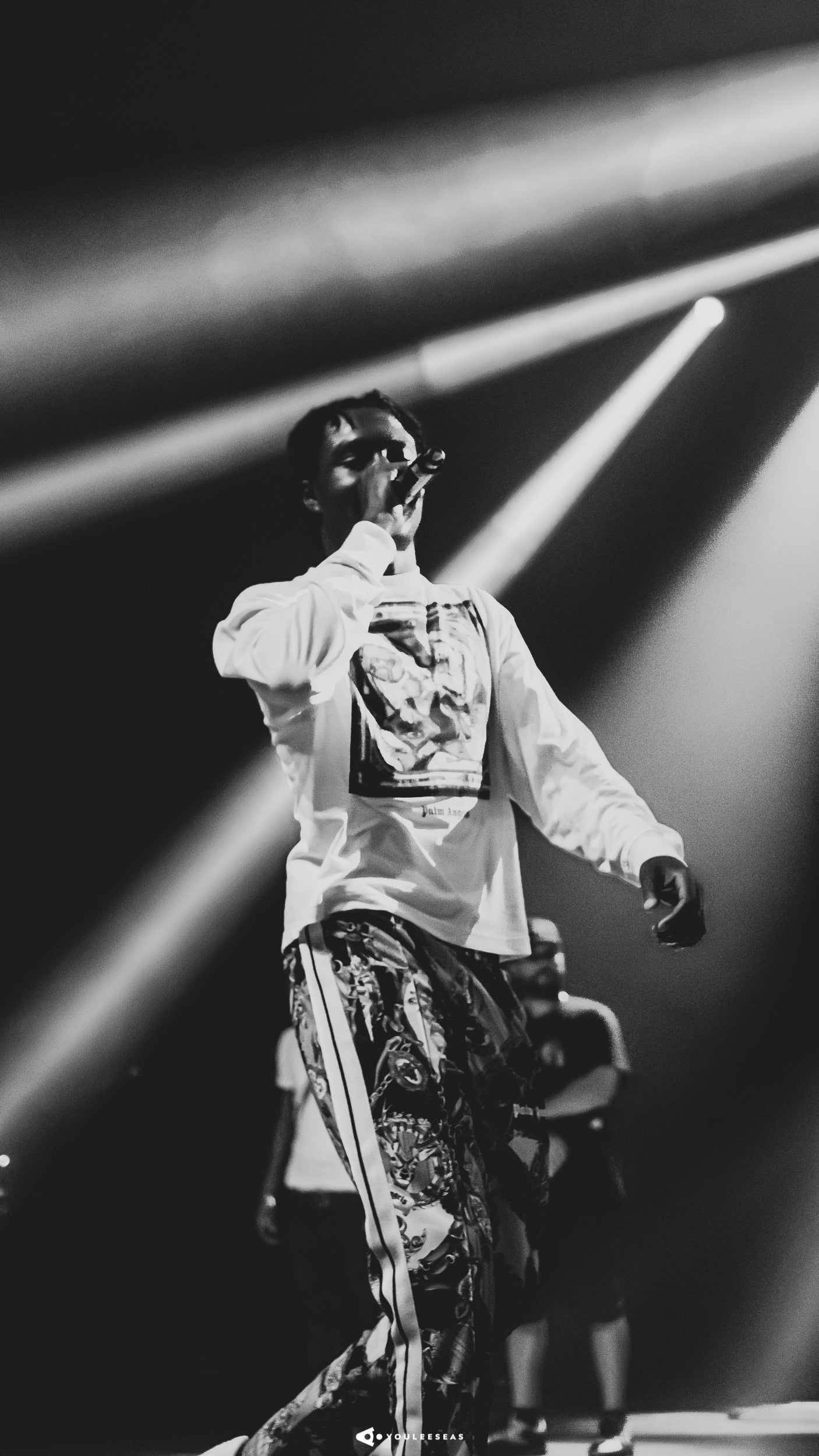 小寶貝 桌布 壁紙 — 一位音樂家在戲劇性的對角聚光燈下，以高對比度的黑白照片在舞台上熱情表演。